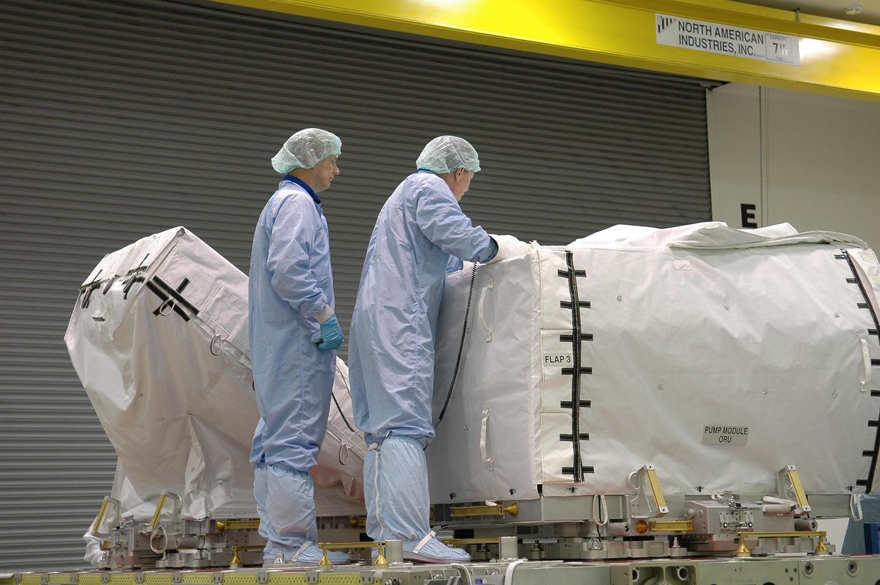 KENNEDY SPACE CENTER, FLA.  -  Mission Specialist Piers Sellers (left)  and Commander Steven Lindsey work with the pump module at the SPACEHAB facility in Cape Canaveral during a Crew Equipment Interface Test. This test allows the astronauts to become familiar with equipment they will be using on their upcoming mission. STS-121 is scheduled to launch in July aboard Space Shuttle Discovery.  Photo credit: NASA/Kim Shiflett