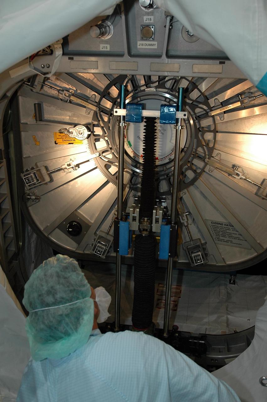 KENNEDY SPACE CENTER, FLA.  -   In the Space Station Processing Facility, a technician observes as the hatch closes on the multi-purpose logistics module Leonardo. The module is part of the payload for Space Shuttle Discovery on mission STS-121 to the International Space Station. Discovery is scheduled to launch in July.  Photo credit: NASA/Jack Pfaller