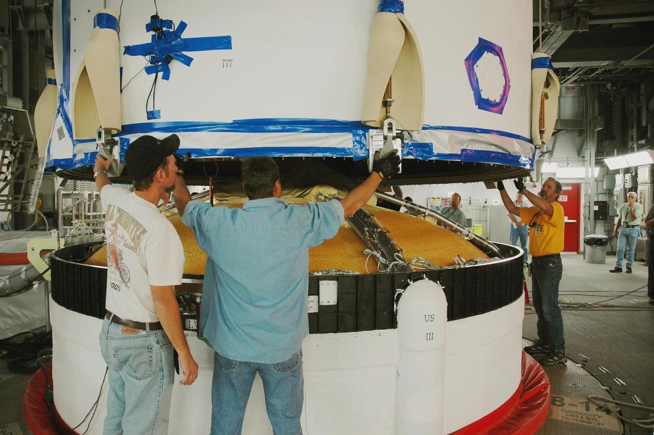 KENNEDY SPACE CENTER, FLA. - In the mobile service tower on Launch Complex 37 at Cape Canaveral Air Force Station in Florida, workers guide the GOES-N spacecraft toward the second stage of the Boeing Delta IV rocket for mating. GOES-N is the latest in a series of Geostationary Operational Environmental Satellites for NOAA and NASA, providing continuous monitoring necessary for intensive data analysis. GOES-N is scheduled to be launched May 18 in an hour-long window between 6:14 and 7:14 p.m. EDT. Photo credit: NASA/Charisse Nahser