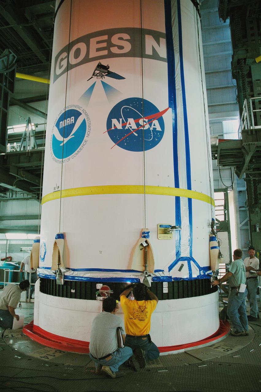 KENNEDY SPACE CENTER, FLA. - In the mobile service tower on Launch Complex 37 at Cape Canaveral Air Force Station in Florida, workers check the attach points on the GOES-N spacecraft and Boeing Delta IV rocket. GOES-N is the latest in a series of Geostationary Operational Environmental Satellites for NOAA and NASA, providing continuous monitoring necessary for intensive data analysis. GOES-N is scheduled to be launched May 18 in an hour-long window between 6:14 and 7:14 p.m. EDT. Photo credit: NASA/Charisse Nahser
