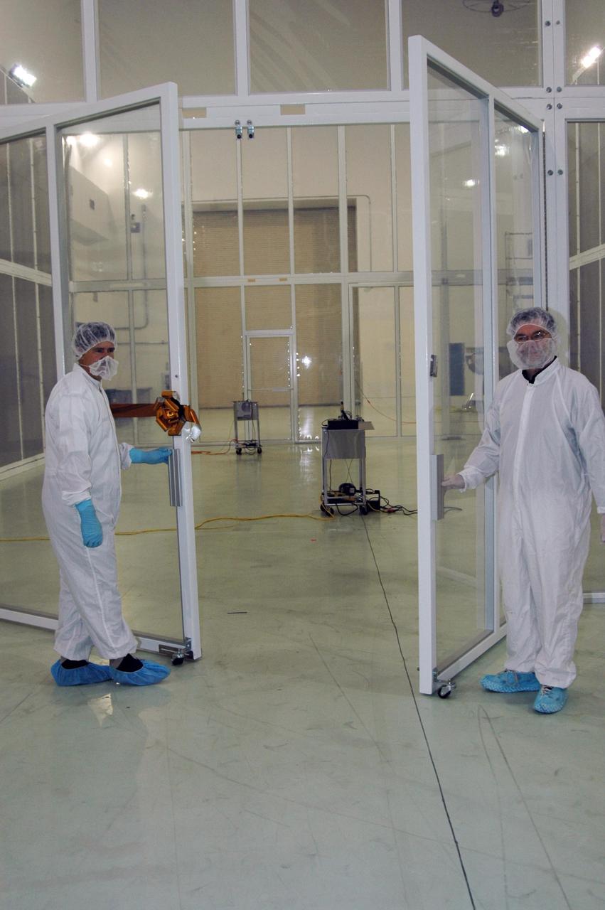 KENNEDY SPACE CENTER, FLA. - Dwayne Light (left), director of Florida Operations, Astrotech, and Jim Adams, deputy project manager for NASA's Solar Terrestrial Relations Observatory (STEREO), Goddard Space Flight Center, ceremonially open the doors of the new class 10,000 clean-room enclosure at Astrotech, signaling the enclosure is ready for operation.  Astrotech is a payload processing facility in Titusville, near Kennedy Space Center. This clean-room enclosure, within the high bay at Astrotech, meets the additional stringent cleanliness requirements necessary for processing STEREO for launch.  The enclosure was designed and constructed by Astrotech to meet the spacecraft requirements provided by STEREO project management at NASA's Goddard Space Flight Center, Greenbelt, Md. STEREO consists of two spacecraft whose mission is the first to take measurements of the sun and solar wind in 3-D. Launch aboard a Boeing Delta II rocket from Launch Complex 17 on Cape Canaveral Air Force Station is scheduled to occur over the summer. Photo credit: NASA/Dimitri Gerondidakis