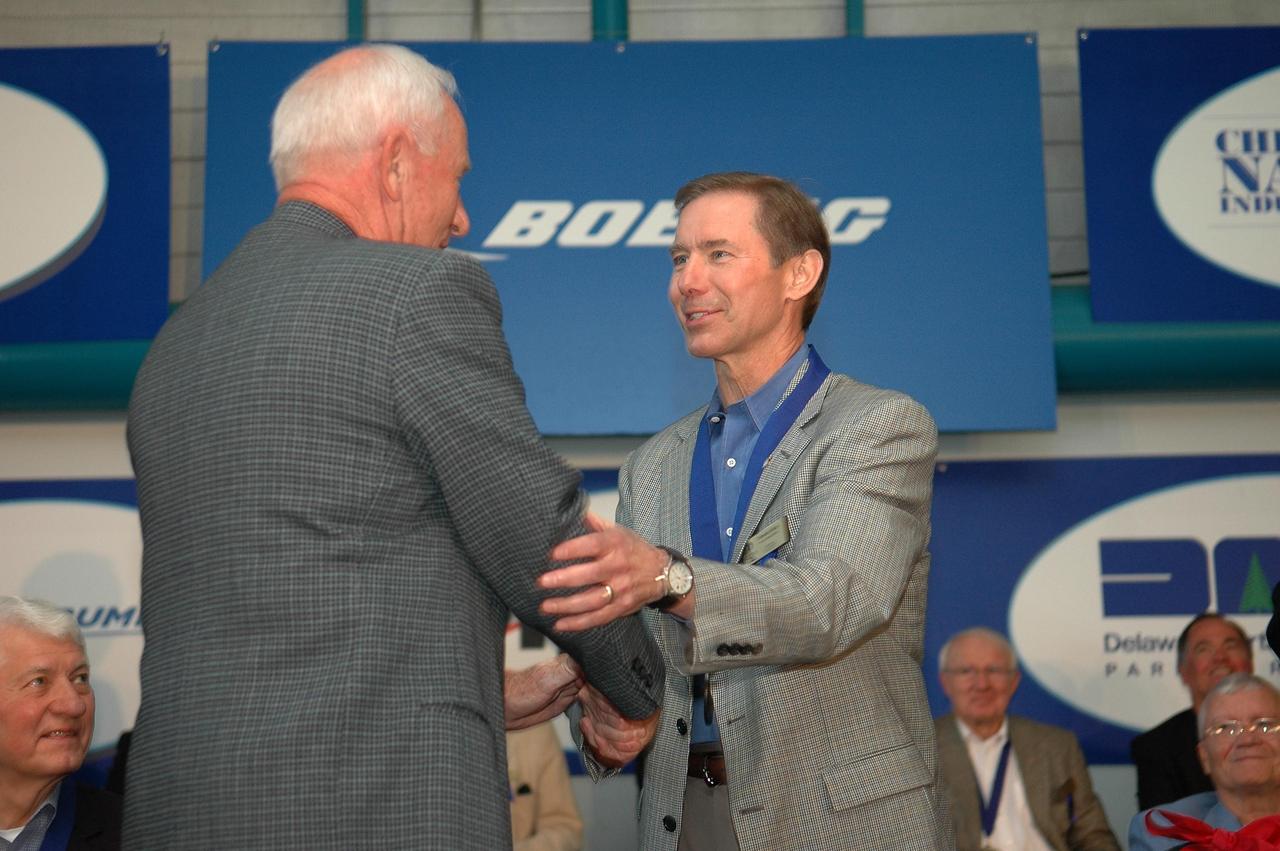 KENNEDY SPACE CENTER, FLA. - Brewster H. Shaw Jr. (right) accepts congratulations from Al Worden, U.S. Astronaut Hall of Fame member and chairman of the Astronaut Scholarship Foundation. The occasion is the 2006 induction ceremony for the U.S. Astronaut Hall of Fame, held in the Apollo/Saturn V Center. The inductees for 2006 are former NASA astronauts Shaw, Henry "Hank" Hartsfield Jr., and Charles F. Bolden Jr. Shaw flew on three space shuttle missions including STS-9, STS-61B, STS-28, logging 533 hours in space. The U.S. Astronaut Hall of Fame now includes 63 space explorers. Photo credit: NASA/Kim Shiflett