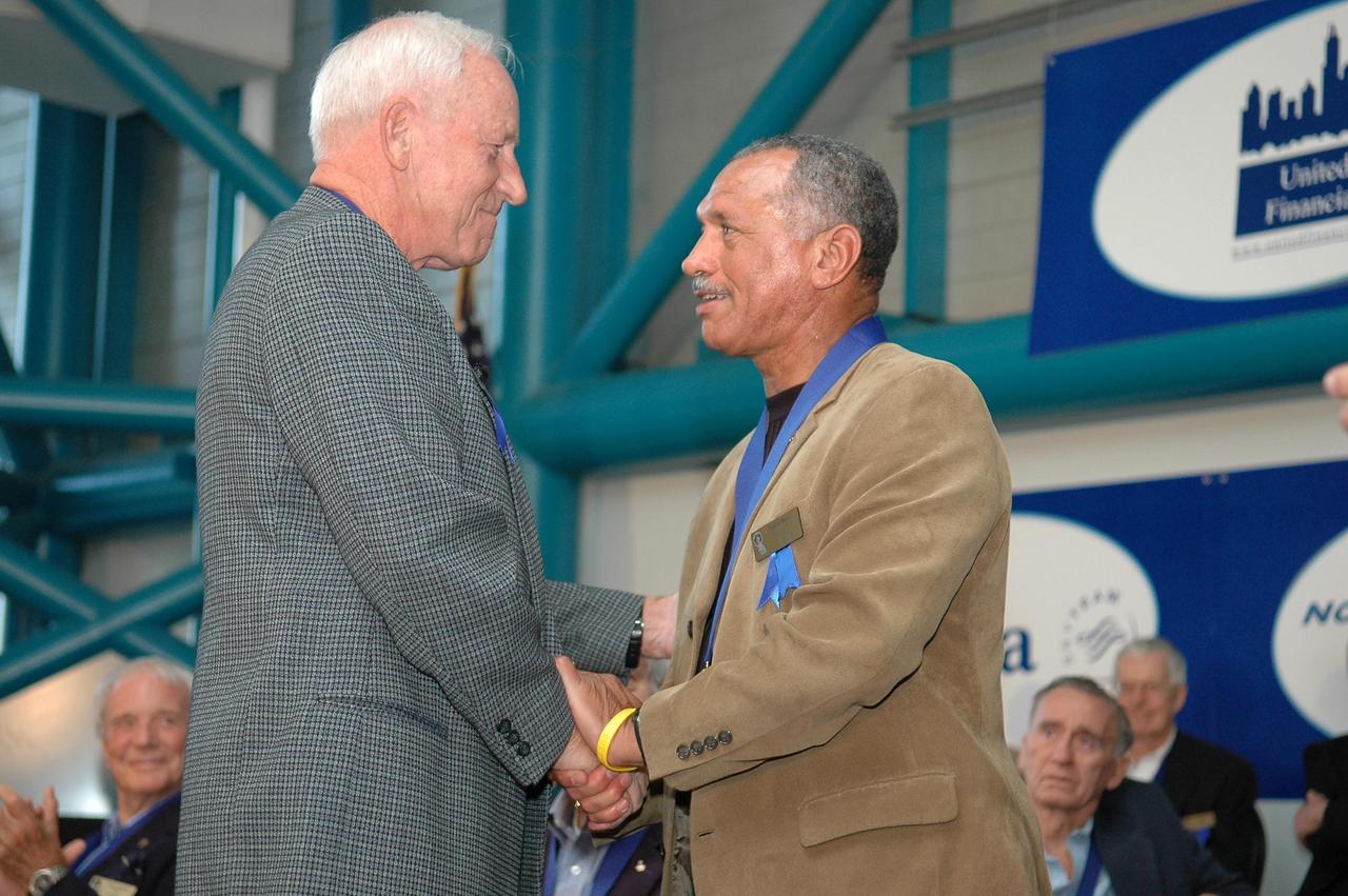 KENNEDY SPACE CENTER, FLA. - Charles F. Bolden Jr. (right) accepts congratulations from Al Worden, U.S. Astronaut Hall of Fame member and chairman of the Astronaut Scholarship Foundation. The occasion is the 2006 induction ceremony for the U.S. Astronaut Hall of Fame, held in the Apollo/Saturn V Center. The inductees for 2006 are former NASA astronauts Bolden, Henry "Hank" Hartsfield Jr. and Brewster H. Shaw Jr. Bolden flew on four space shuttle missions including STS-61C, STS-31, STS-45 and STS-60, logging 680 hours in space. The U.S. Astronaut Hall of Fame now includes 63 space explorers. Photo credit: NASA/Kim Shiflett