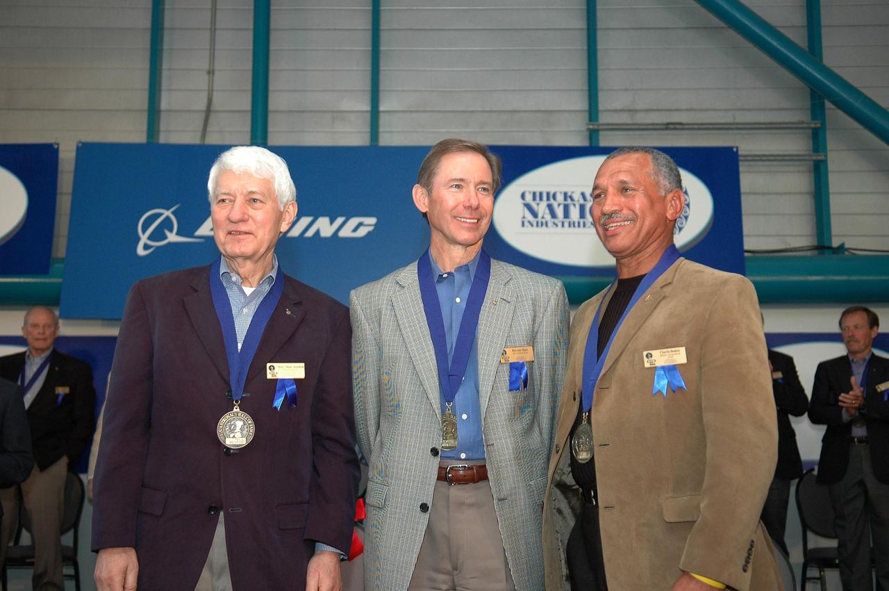 KENNEDY SPACE CENTER, FLA. - From left, Henry "Hank" Hartsfield Jr., Brewster H. Shaw Jr. and Charles F. Bolden Jr. are cheered by the standing-room-only crowd in the Apollo/Saturn V Center upon their induction into the U.S. Astronaut Hall of Fame which now includes 63 space explorers. Photo credit: NASA/Kim Shiflett