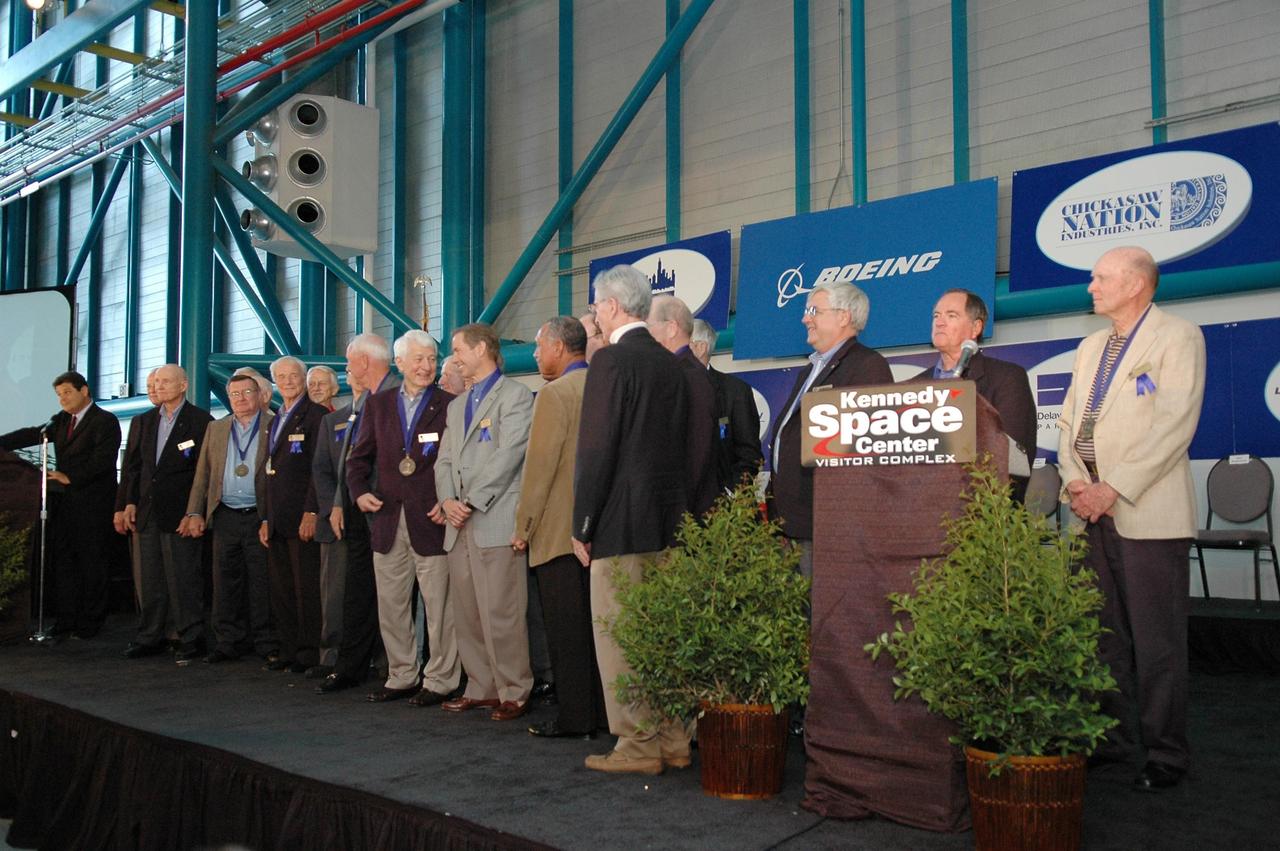 KENNEDY SPACE CENTER, FLA. - Former NASA astronauts and members of the U.S. Astronaut Hall of Fame are presented to the standing-room-only crowd at the 2006 induction ceremony in the Apollo/Saturn V Center. The inductees to the U.S. Astronaut Hall of Fame for 2006 (center stage, from left) are Henry "Hank" Hartsfield Jr., Brewster H. Shaw Jr. and Charles F. Bolden Jr. The U.S. Astronaut Hall of Fame now includes 63 space explorers. Photo credit: NASA/Kim Shiflett