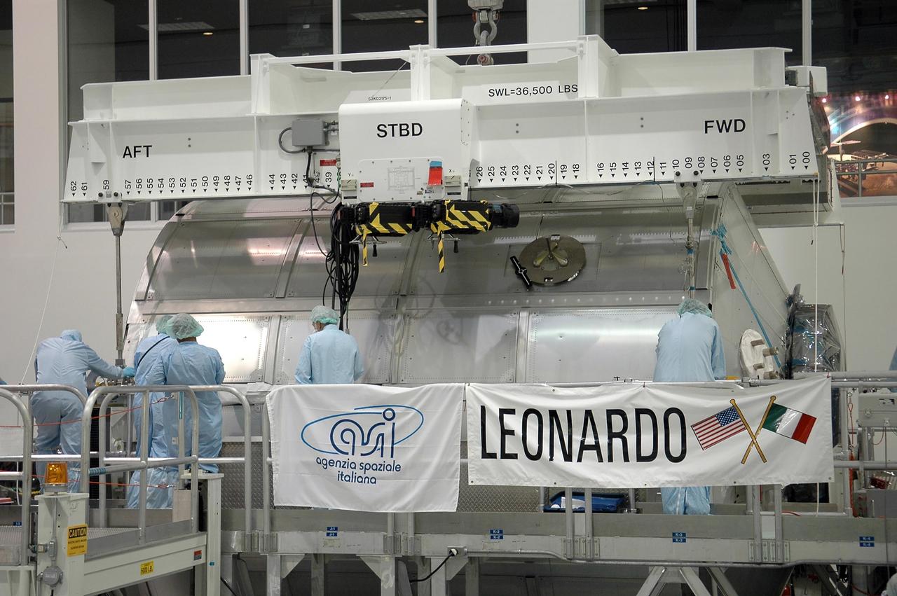 KENNEDY SPACE CENTER, FLA. - In the Space Station Processing Facility, workers attach an overhead crane to the multi-purpose logistics module Leonardo, which is being moved to the payload transportation canister for transfer to Launch Pad 39B, where it will be installed in Space Shuttle Discovery's payload bay. Part of the payload for mission STS-121, Leonardo carries tons of supplies and experiments for the International Space Station and its crew. Discovery is scheduled to be launched in a window that extends from July 1 to July 19. Photo credit: NASA/Kim Shiflett