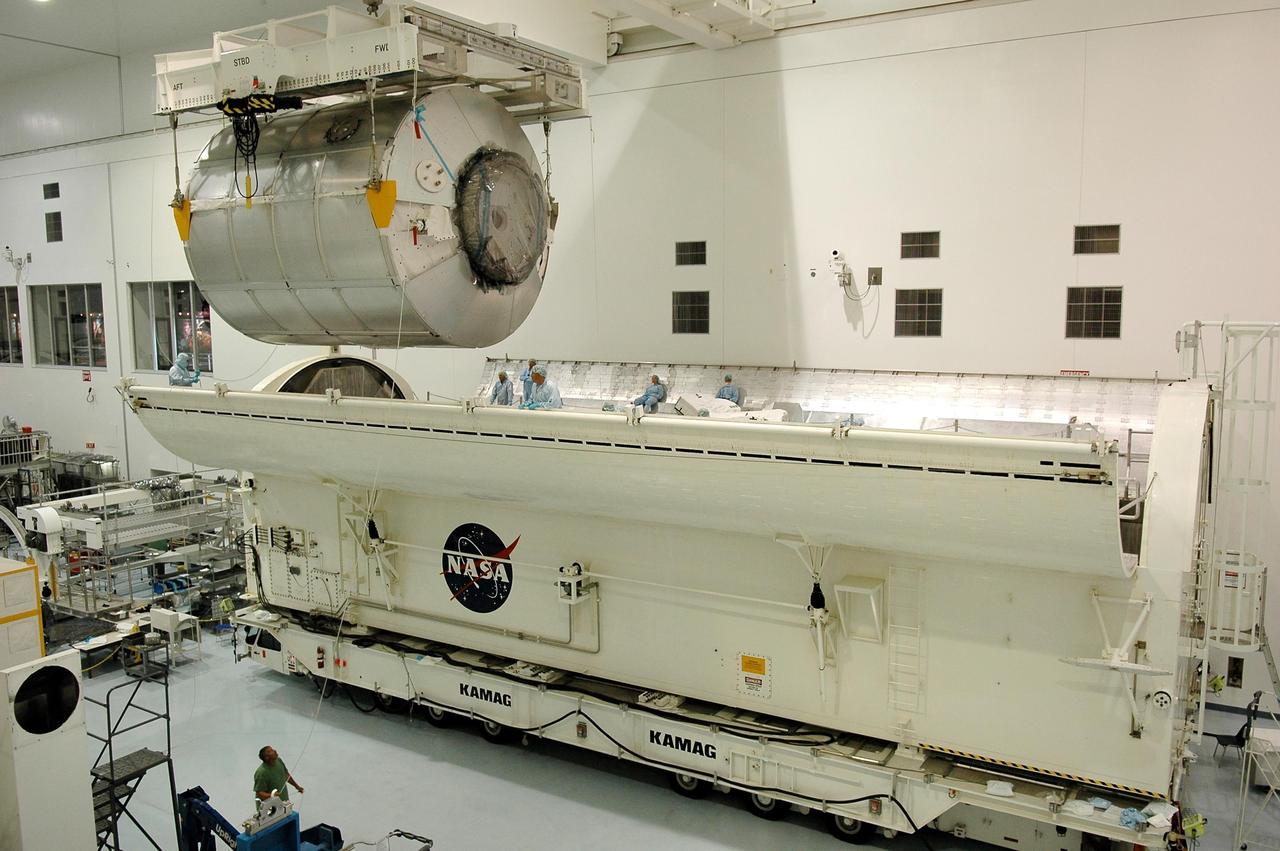 KENNEDY SPACE CENTER, FLA. - In the Space Station Processing Facility, the multi-purpose logistics module Leonardo moves above the payload transportation canister.  The module will be lowered into and installed in the canister for transfer to Launch Pad 39B.  At the pad, the module will be installed in Space Shuttle Discovery's payload bay.  Part of the payload for mission STS-121, Leonardo carries tons of supplies and experiments for the International Space Station and its crew.  Discovery is scheduled to be launched in a window that extends from July 1 to July 19.   Photo credit: NASA/Kim Shiflett