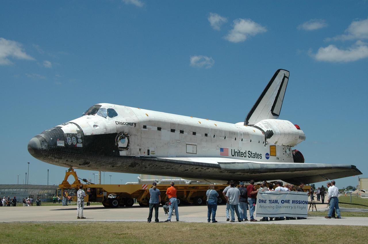 KENNEDY SPACE CENTER, FLA. - The orbiter Discovery, sitting on an orbiter transporter, turns away from NASA's Orbiter Processing Facility to roll toward the Vehicle Assembly Building (VAB). The rollover to the VAB marks the start of the journey to the launch pad and, ultimately, launch. Once inside the VAB, Discovery will be raised to vertical and lifted up and over into high bay 3 for stacking with its redesigned external tank and twin solid rocket boosters. The rollout of Space Shuttle Discovery to Launch Pad 39B is expected in approximately a week. Launch of Discovery on mission STS-121 is scheduled to take place in a window extending July 1 to July 19. Photo credit: NASA/Jim Grossmann