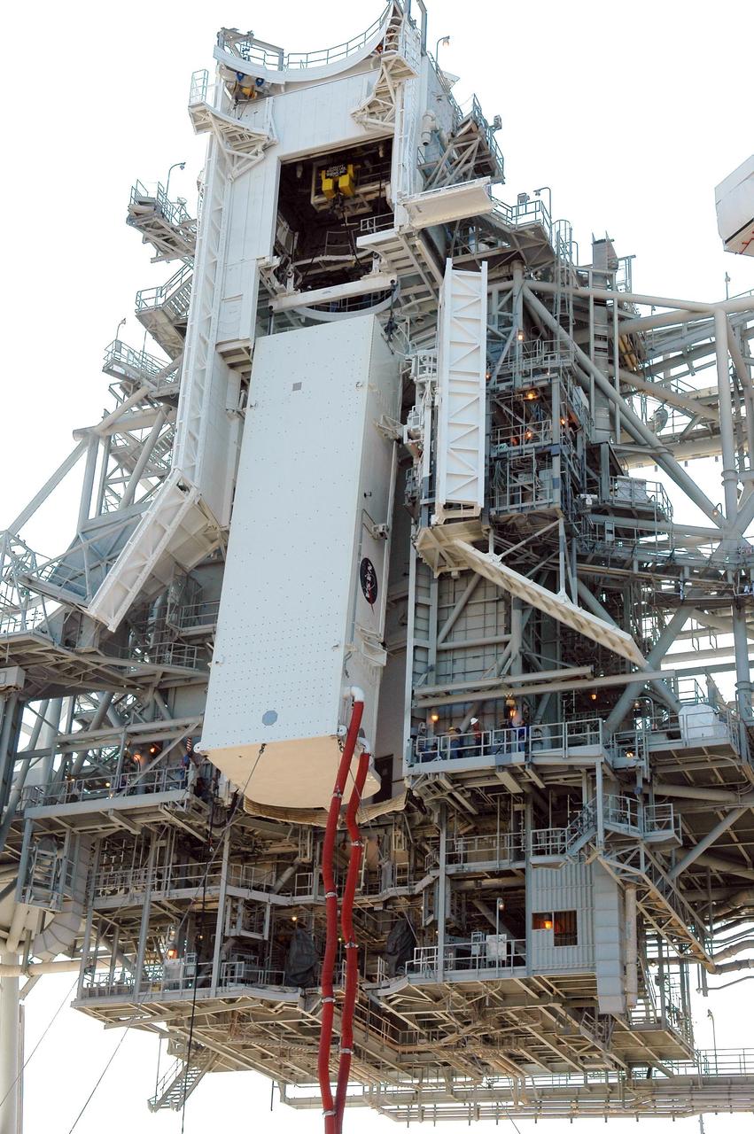 KENNEDY SPACE CENTER, FLA. -- On Launch Pad 39B at NASA's Kennedy Space Center, the payload canister holding Space Shuttle Discovery's payloads nears the payload changeout room on the rotating service structure. The red umbilical lines are still attached. The payload changeout room provides an environmentally clean or "white room" condition in which to receive a payload transferred from a protective payload canister. After the shuttle arrives at the pad, the rotating service structure will close around it and the payloads, which include the multi-purpose logistics module and integrated cargo carrier, will then be transferred from the changeout room into Discovery's payload bay. Discovery's launch to the International Space Station on mission STS-121 is targeted for July 1 in a launch window that extends to July 19. During the 12-day mission, crew members will test new hardware and techniques to improve shuttle safety. Photo credit: NASA/Kim Shiflett