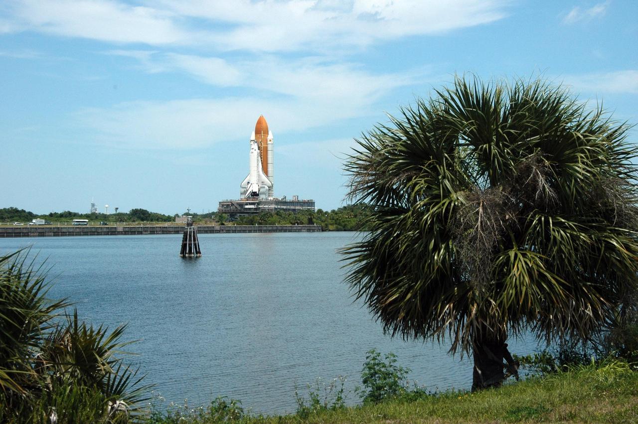 KENNEDY SPACE CENTER, FLA. -- Viewed from across the turn basin, Space Shuttle Discovery, on top of the mobile launcher platform and crawler-transporter, makes its way to Launch Pad 39B. First motion in NASA's Vehicle Assembly Building was at 12:45 p.m. EDT. The rollout is an important step before launch of Discovery on mission STS-121 to the International Space Station. Discovery's launch is targeted for July 1 in a launch window that extends to July 19. During the 12-day mission, Discovery's crew will test new hardware and techniques to improve shuttle safety, as well as deliver supplies and make repairs to the station. Photo credit: NASA/Ken Thornsley