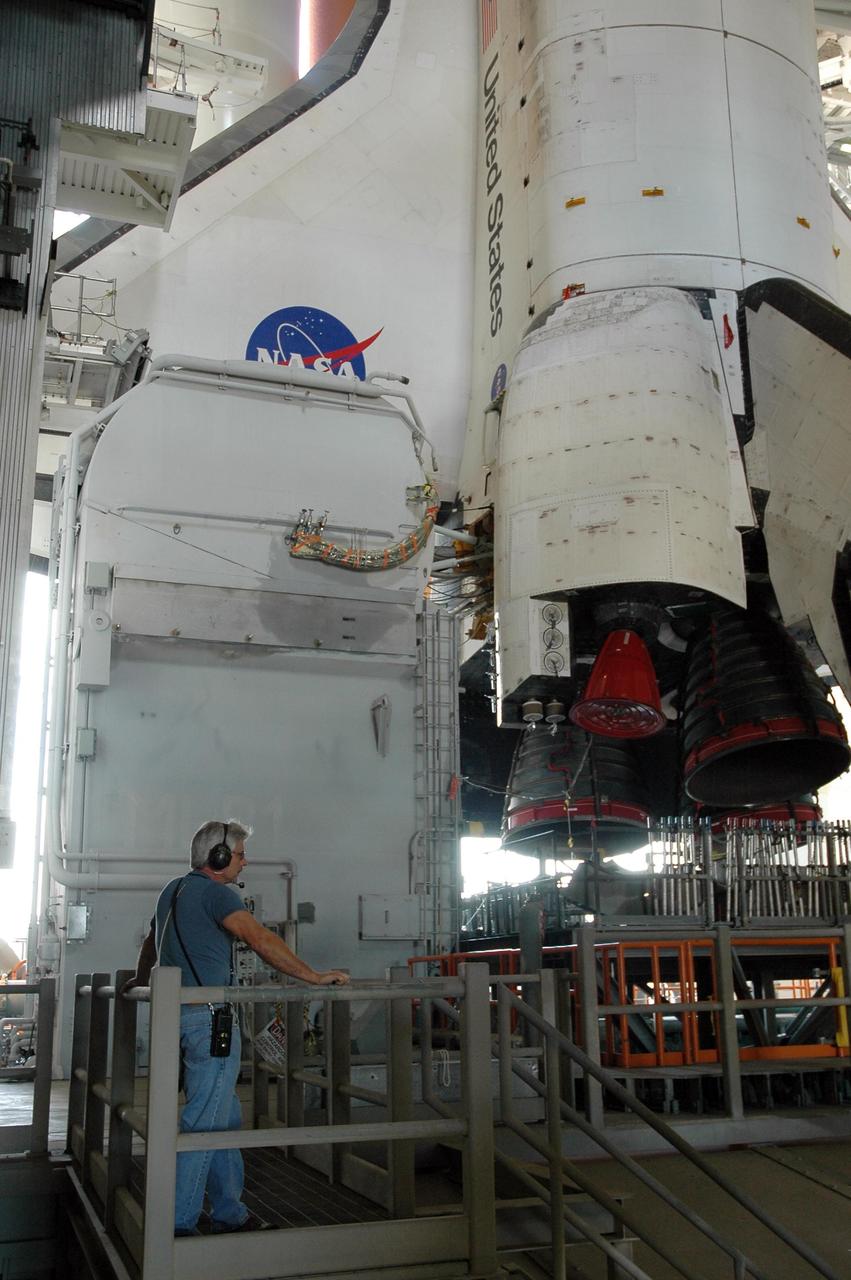 KENNEDY SPACE CENTER, FLA. -- A worker on a stand behind the mobile launcher platform holding Space Shuttle Discovery waits for first motion of the shuttle out of NASA's Vehicle Assembly Building. The rollout is an important step before launch of Discovery on mission STS-121 to the International Space Station. Discovery's launch is targeted for July 1 in a launch window that extends to July 19. During the 12-day mission, Discovery's crew will test new hardware and techniques to improve shuttle safety, as well as deliver supplies and make repairs to the station. Photo credit: NASA/Jack Pfaller