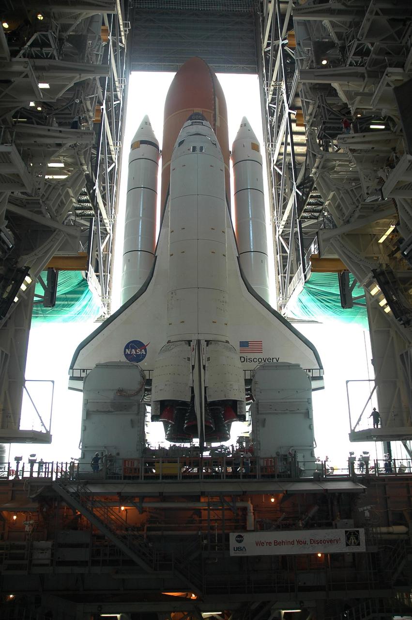 KENNEDY SPACE CENTER, FLA. -- From high bay 3 of NASA's Vehicle Assembly Building, Space Shuttle Discovery begins its slow 4.2-mile journey via the crawlerway to Launch Pad 39B. The shuttle rests on a mobile launcher platform that sits atop a crawler-transporter. First motion was at 12:45 p.m. EDT. The rollout is an important step before launch of Discovery on mission STS-121 to the International Space Station. Discovery's launch is targeted for July 1 in a launch window that extends to July 19. During the 12-day mission, Discovery's crew will test new hardware and techniques to improve shuttle safety, as well as deliver supplies and make repairs to the station. Photo credit: NASA/Jack Pfaller