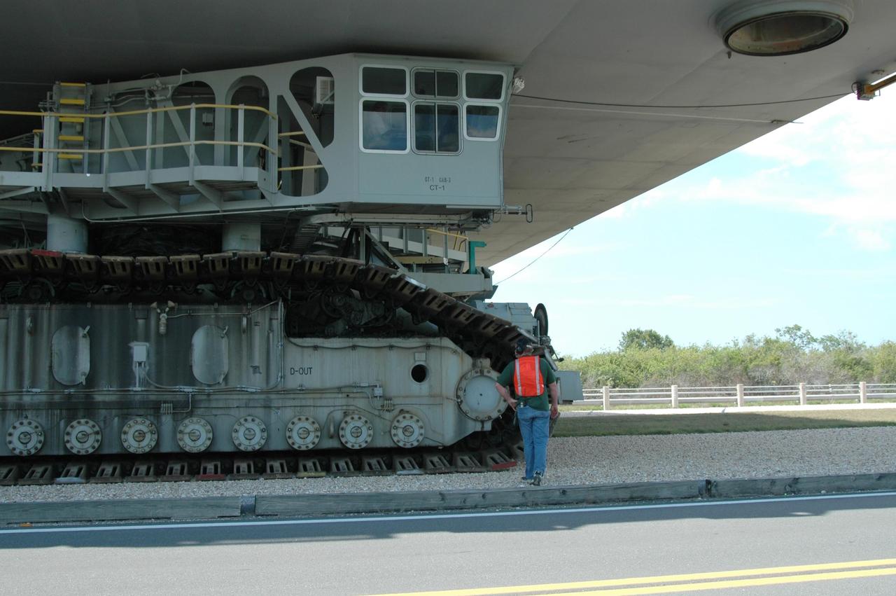KENNEDY SPACE CENTER, FLA. -- A worker checks the movement of the crawler-transporter carrying Space Shuttle Discovery on its rollout to Launch Pad 39B. The bottom of the mobile launcher platform, on which the shuttle rests, can be seen above the cab on the crawler. First motion of the shuttle leaving NASA's Vehicle Assembly Building was at 12:45 p.m. EDT. The rollout is an important step before launch of Discovery on mission STS-121 to the International Space Station. Discovery's launch is targeted for July 1 in a launch window that extends to July 19. During the 12-day mission, Discovery's crew will test new hardware and techniques to improve shuttle safety, as well as deliver supplies and make repairs to the station. Photo credit: NASA/Dimitri Gerondidakis