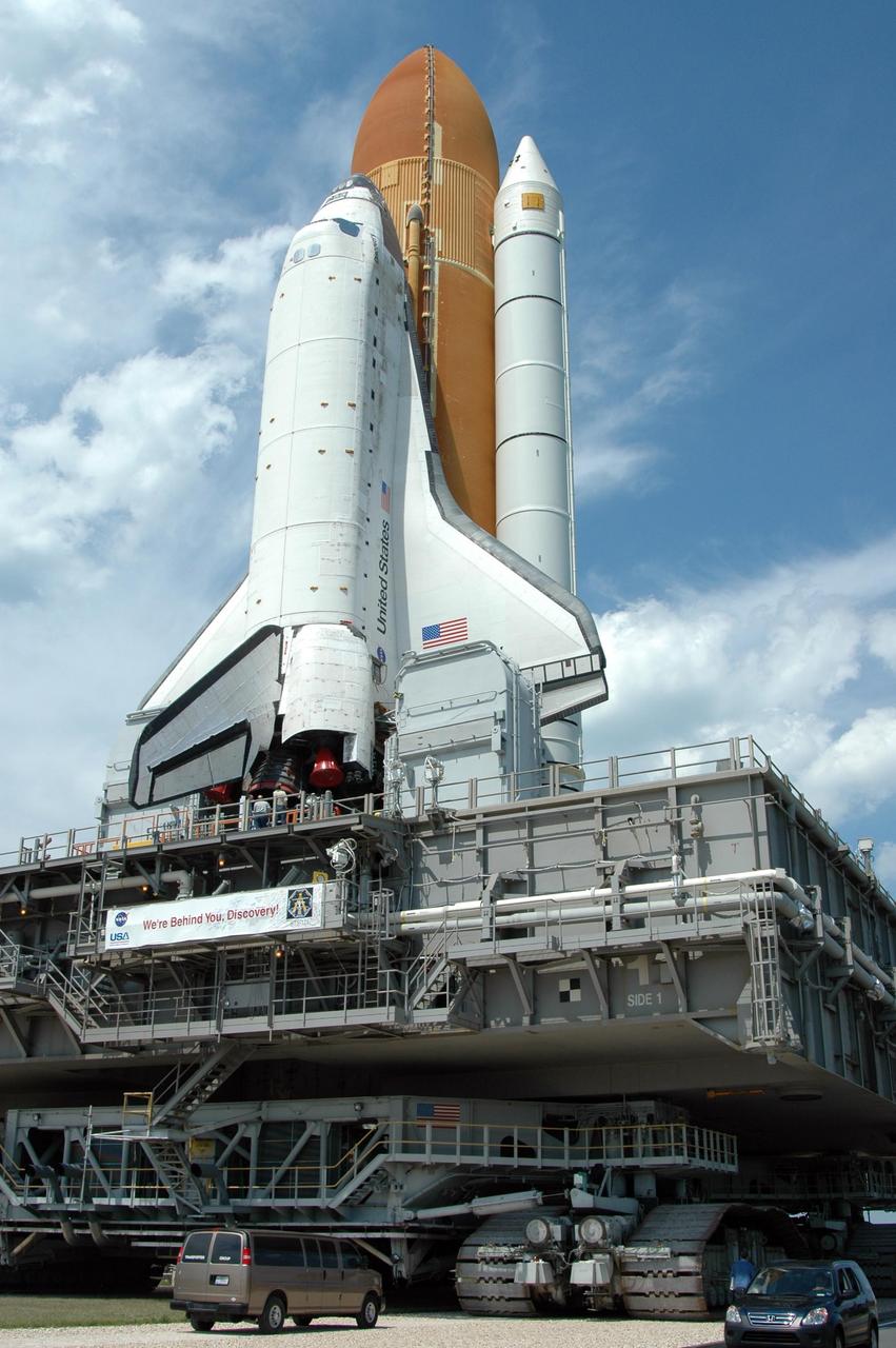 KENNEDY SPACE CENTER, FLA. -- Space Shuttle Discovery rolls toward Launch Pad 39B. The shuttle rests on the mobile launcher platform, which is being carried by the crawler-transporter underneath. First motion of the shuttle leaving NASA's Vehicle Assembly Building was at 12:45 p.m. EDT. The rollout is an important step before launch of Discovery on mission STS-121 to the International Space Station. Discovery's launch is targeted for July 1 in a launch window that extends to July 19. During the 12-day mission, Discovery's crew will test new hardware and techniques to improve shuttle safety, as well as deliver supplies and make repairs to the station. Photo credit: NASA/Dimitri Gerondidakis