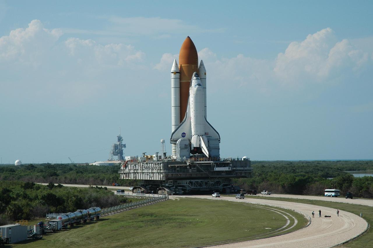 KENNEDY SPACE CENTER, FLA. -- Space Shuttle Discovery turns the corner on the crawlerway leading to Launch Pad 39B (in the background). The rollout is an important step before launch of Discovery on mission STS-121 to the International Space Station. First motion of the shuttle leaving NASA's Vehicle Assembly Building was at 12:45 p.m. EDT. Discovery's launch is targeted for July 1 in a launch window that extends to July 19. During the 12-day mission, Discovery's crew will test new hardware and techniques to improve shuttle safety, as well as deliver supplies and make repairs to the station. Photo credit: NASA/Dimitri Gerondidakis