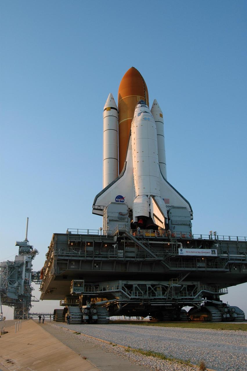 KENNEDY SPACE CENTER, FLA. --  Space Shuttle Discovery nears its destination on its rollout to Launch Pad 39B.  Discovery rests on top of the mobile launcher platform, which is carried by the crawler-transporter underneath.  First motion of the shuttle leaving NASA's Vehicle Assembly Building was at 12:45 p.m. EDT. The 4.2-mile journey from the VAB to the pad takes approximately 8 hours.  The rollout is an important step before launch of Discovery on mission STS-121 to the International Space Station.  Discovery's launch is targeted for July 1 in a launch window that extends to July 19. During the 12-day mission, Discovery's crew will test new hardware and techniques to improve shuttle safety, as well as deliver supplies and make repairs to the station.  Photo credit: NASA/Dimitri Gerondidakis