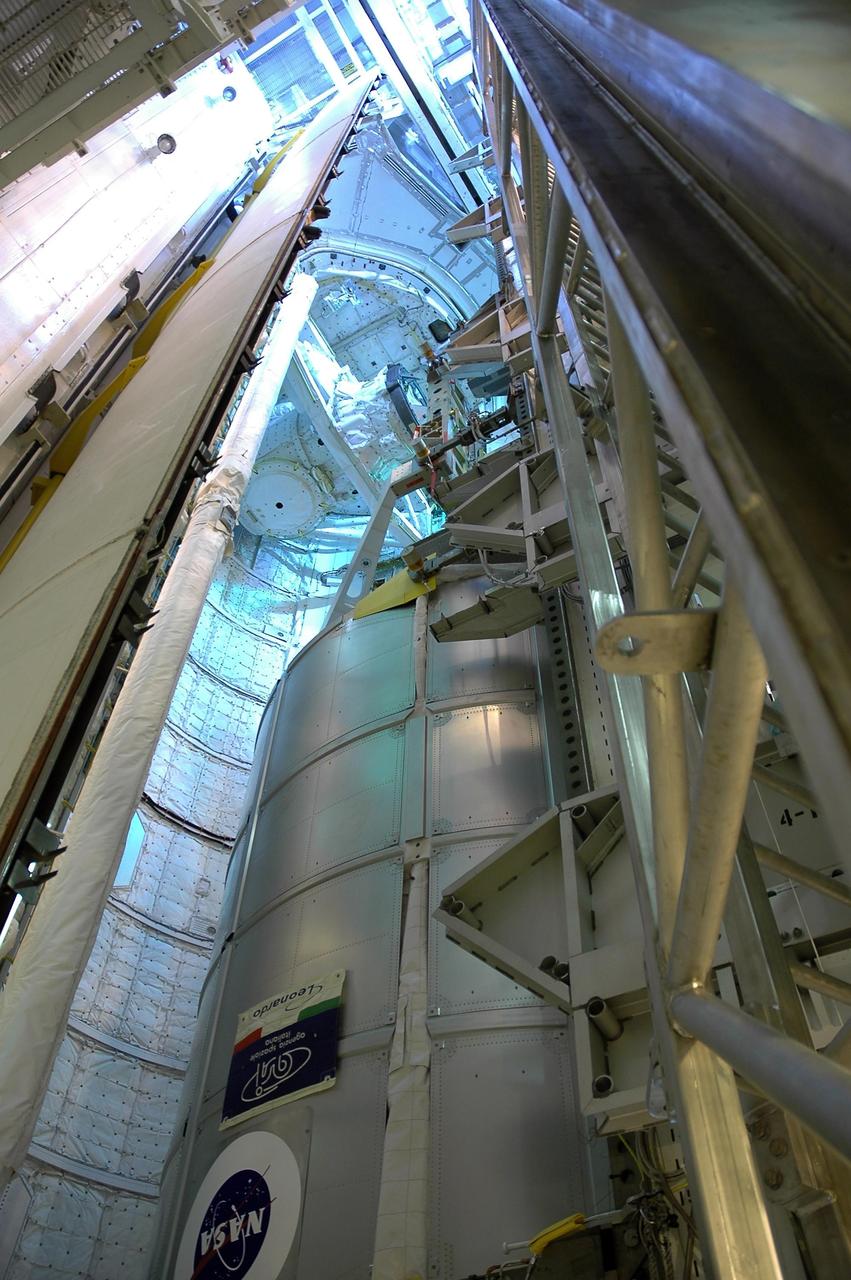KENNEDY SPACE CENTER, FLA. --   From inside the payload changeout room on the rotating service structure on Launch Pad 39B, the multi-purpose logistics module Leonardo is lowered into Space Shuttle Discovery's payload bay.   The payload ground-handling mechanism (PGHM) is used to transfer the module into the payload bay.  Leonardo is a reusable logistics carrier. It is the primary delivery system used to resupply and return station cargo requiring a pressurized environment. Leonardo is part of the payload on mission STS-121.  Other payloads include the integrated cargo carrier with the mobile transporter reel assembly and a spare pump module, and the lightweight multi-purpose experiment support structure carrier.  Discovery is scheduled to launch in a window extending from July 1 through July 19. Photo credit: NASA/Jack Pfaller