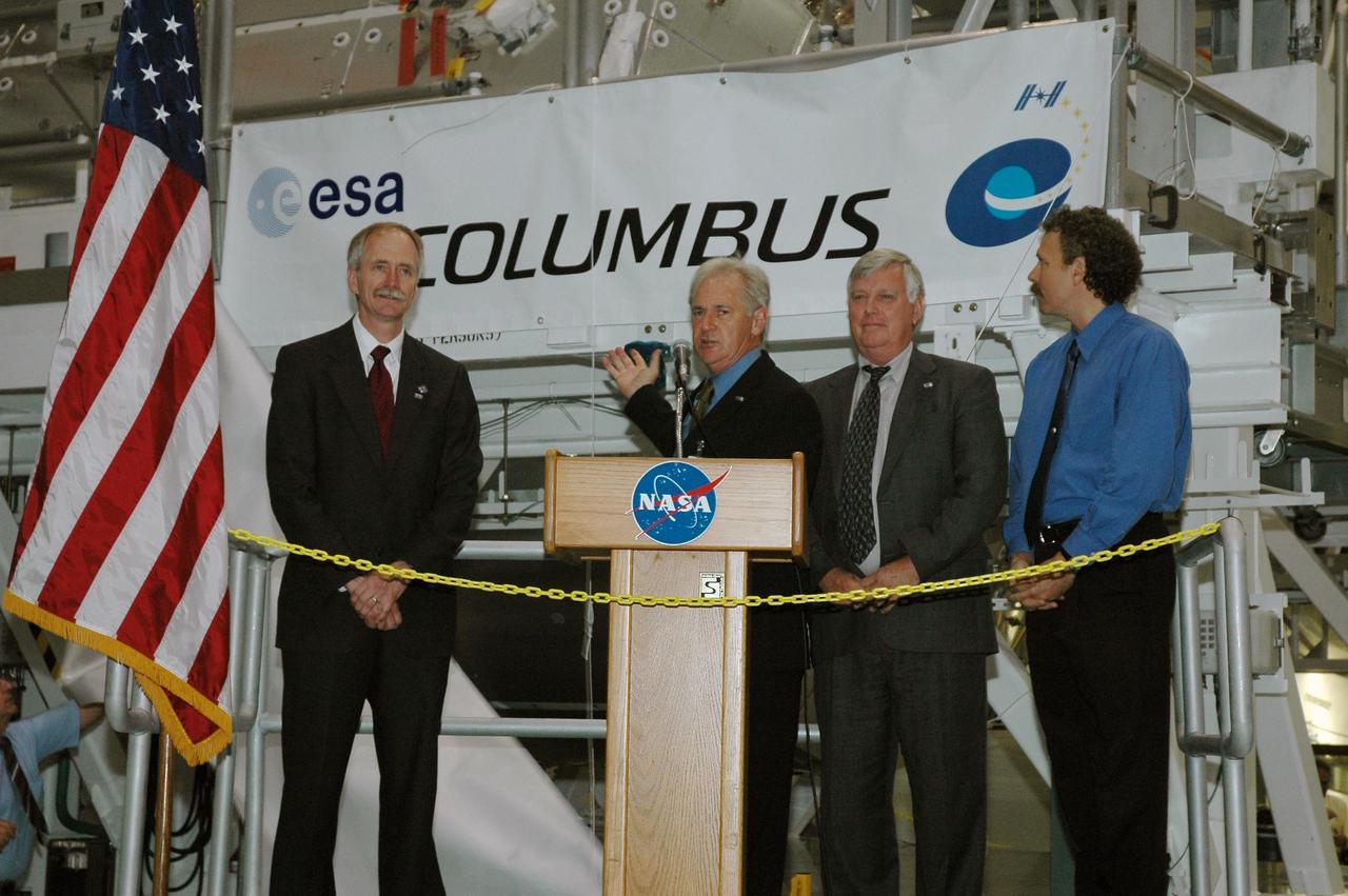 KENNEDY SPACE CENTER, FLA. - The delivery of the Columbus module from Germany to Florida is officially accepted by NASA during a ceremony in the Space Station Processing Facility (SSPF).  Participating in the welcoming ceremony are, from left, William Gerstenmaier, NASA associate administrator for Space Operations; Alan Thirkettle, International Space Station program manager, European Space Agency; Jim Kennedy, director, Kennedy Space Center; and Russell Romanella, director, International Space Station and Payloads Processing. Columbus is the European Space Agency's research laboratory for the International Space Station. The module will be prepared in the SSPF for delivery to the space station on a future space shuttle mission. Columbus will expand the research facilities of the station and provide researchers with the ability to conduct numerous experiments in the life, physical and materials sciences. Photo credit: NASA/Amanda Diller