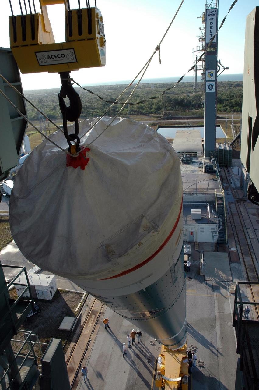 KENNEDY SPACE CENTER, FLA. - The first stage of the Boeing Delta II rocket, slated to launch NASA's Solar Terrestrial Relations Observatory (STEREO), is lifted into a vertical position for installation into the mobile service tower at Pad 17B on Cape Canaveral Air Force Station. Preparations are under way for a liftoff no earlier than July 22. STEREO consists of two spacecraft whose mission is the first to take measurements of the sun and solar wind in 3-D. This new view will improve our understanding of space weather and its impact on the Earth. Photo credit: NASA/Jim Grossmann