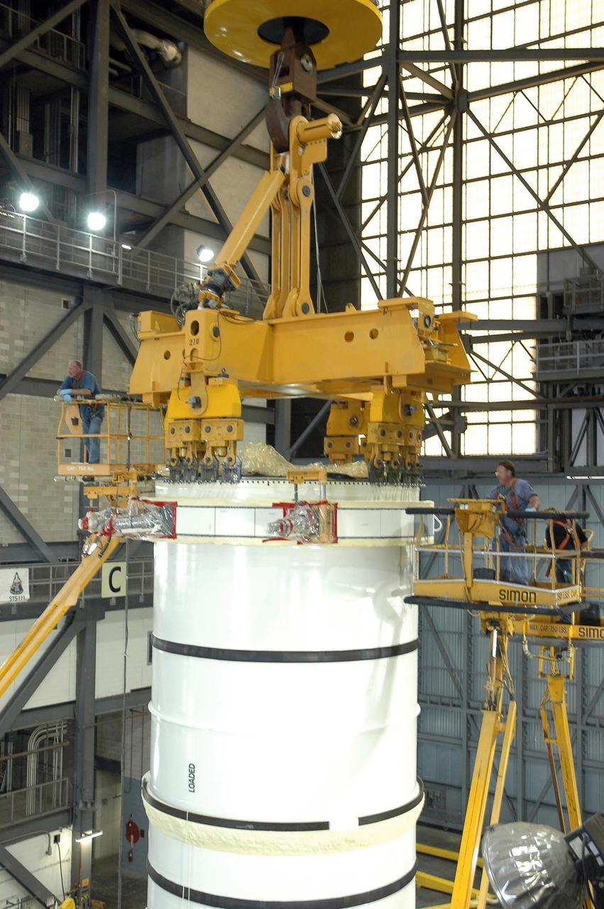 KENNEDY SPACE CENTER, FLA. - In the Vehicle Assembly Building at NASA's Kennedy Space Center, a crane is attached to a solid rocket booster segment sitting on a transporter. The segment will be lifted up into high bay 3 and placed on mobile launcher platform No. 2 for use on mission STS-115. The mission will deliver a truss and other key components to the International Space Station.  Launch is currently scheduled for late August.  Photo credit: NASA/Charisse Nahser