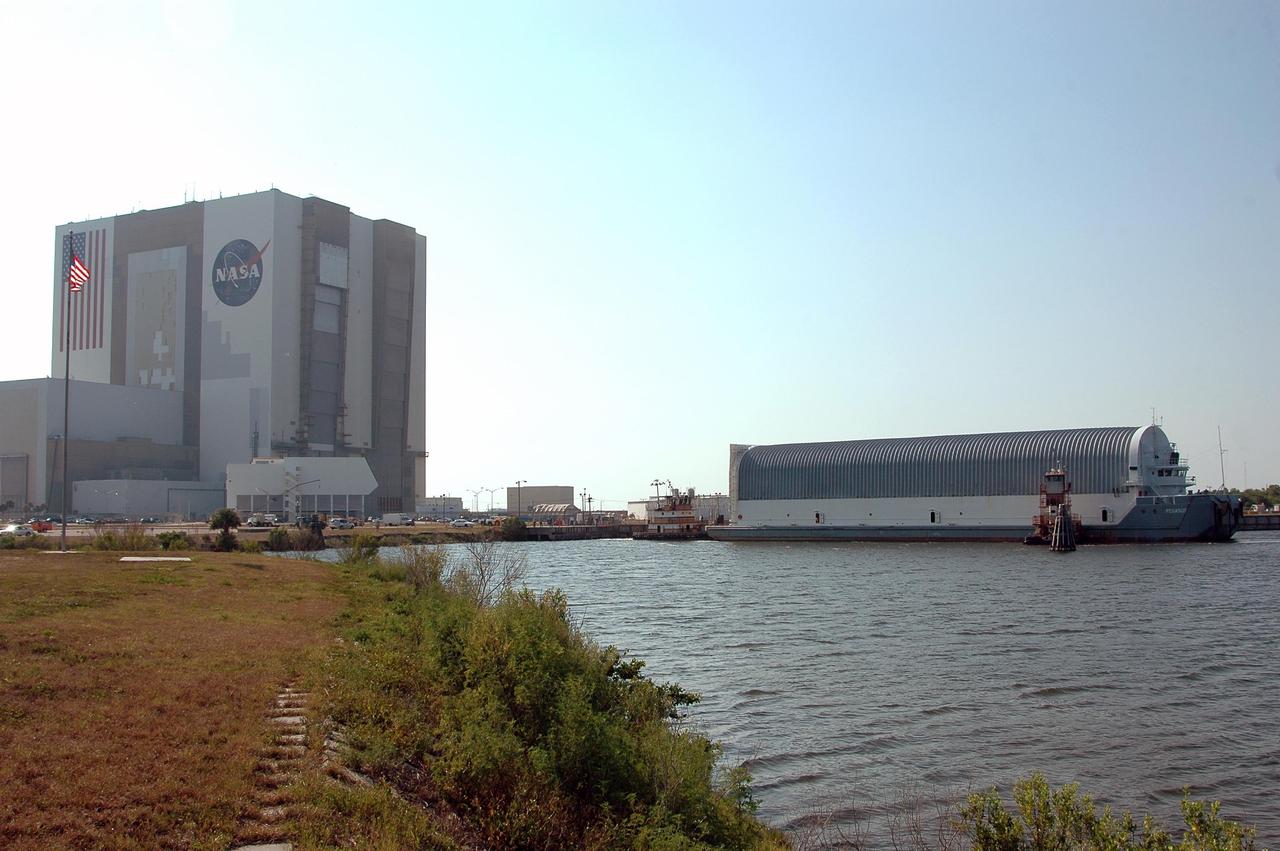 KENNEDY SPACE CENTER, FLA. -    Tug boats maneuver the Pegasus barge next to the dock in the turn basin at the Launch Complex 39 Area.  The barge holds  the redesigned external fuel tank, designated ET-118, that will launch Space Shuttle Atlantis on the next shuttle mission, STS-115. The tank was shipped from the Michoud Assembly Facility in New Orleans.  After off-loading, the tank will be moved into the Vehicle Assembly Building and lifted into a checkout cell for further work. The tank will fly with many major safety changes, including the removal of the protuberance air load ramps. Photo credit: NASA/Kim Shiflett