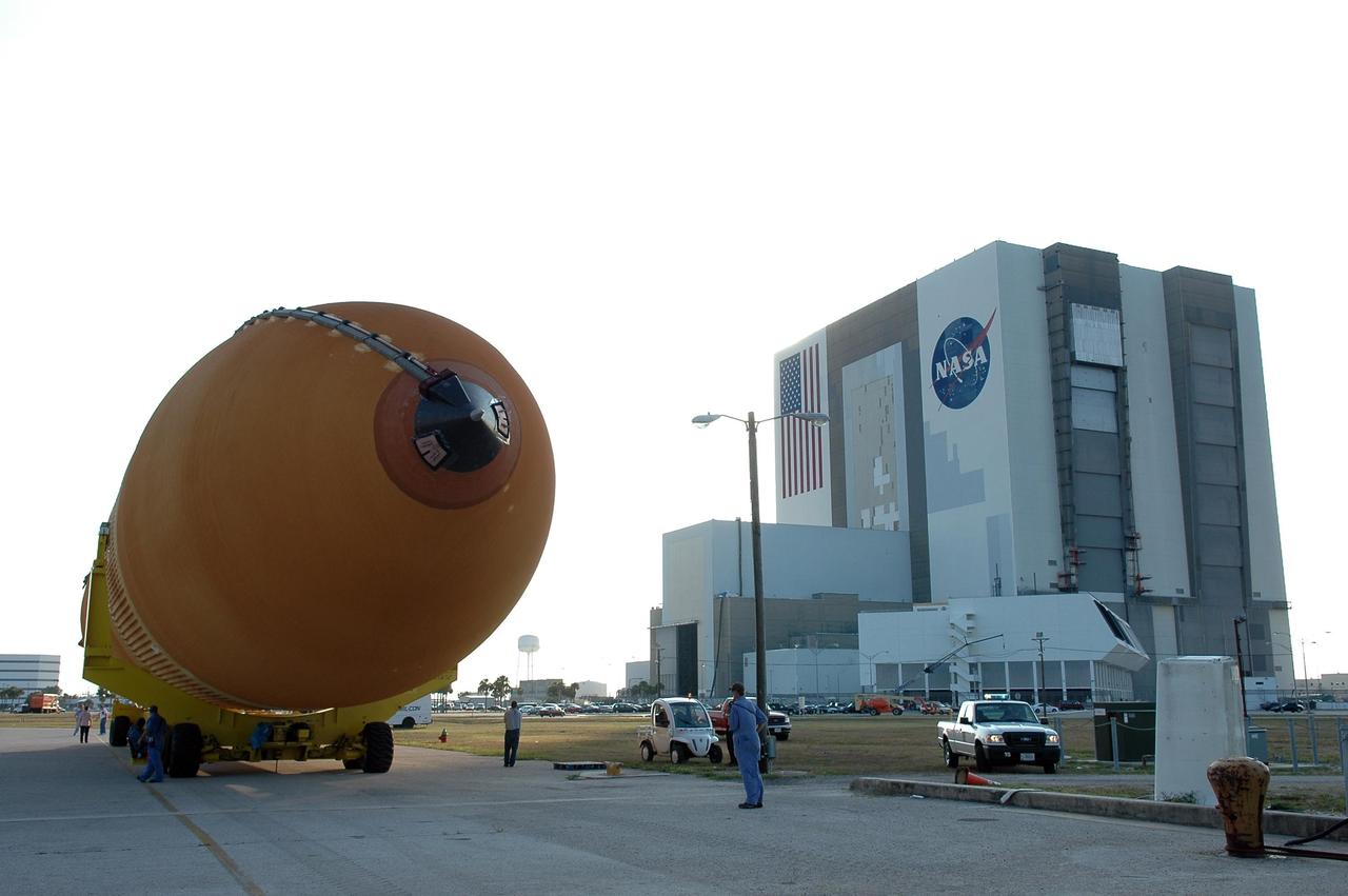 KENNEDY SPACE CENTER, FLA. - The redesigned external fuel tank, designated ET-118, is transported on the road toward the Vehicle Assembly Building, seen at right. The tank, which arrived at KSC aboard the Pegasus barge after a journey from the Michoud Assembly Facility in New Orleans, will be moved into the VAB and lifted into a checkout cell for further work. ET-118, which will fly with many major safety changes, including the removal of the protuberance air load ramps, will launch Space Shuttle Atlantis on the next space shuttle mission, STS-115. Photo credit: NASA/Kim Shiflett