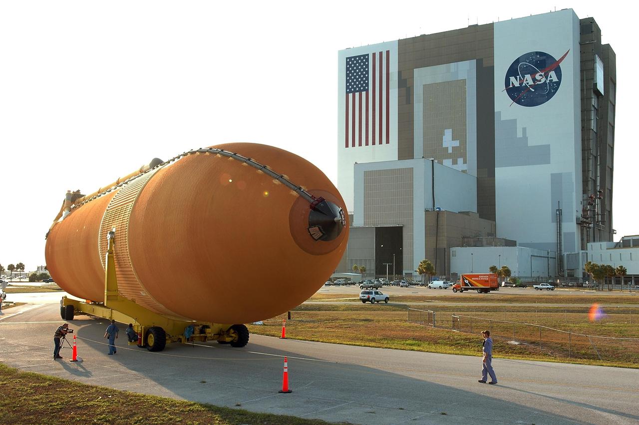 KENNEDY SPACE CENTER, FLA. - The redesigned external fuel tank, designated ET-118, turns the corner toward the Vehicle Assembly Building, seen at right. The tank, which arrived at KSC aboard the Pegasus barge after a journey from the Michoud Assembly Facility in New Orleans, will be moved into the VAB and lifted into a checkout cell for further work. ET-118, which will fly with many major safety changes, including the removal of the protuberance air load ramps, will launch Space Shuttle Atlantis on the next space shuttle mission, STS-115. Photo credit: NASA/Kim Shiflett