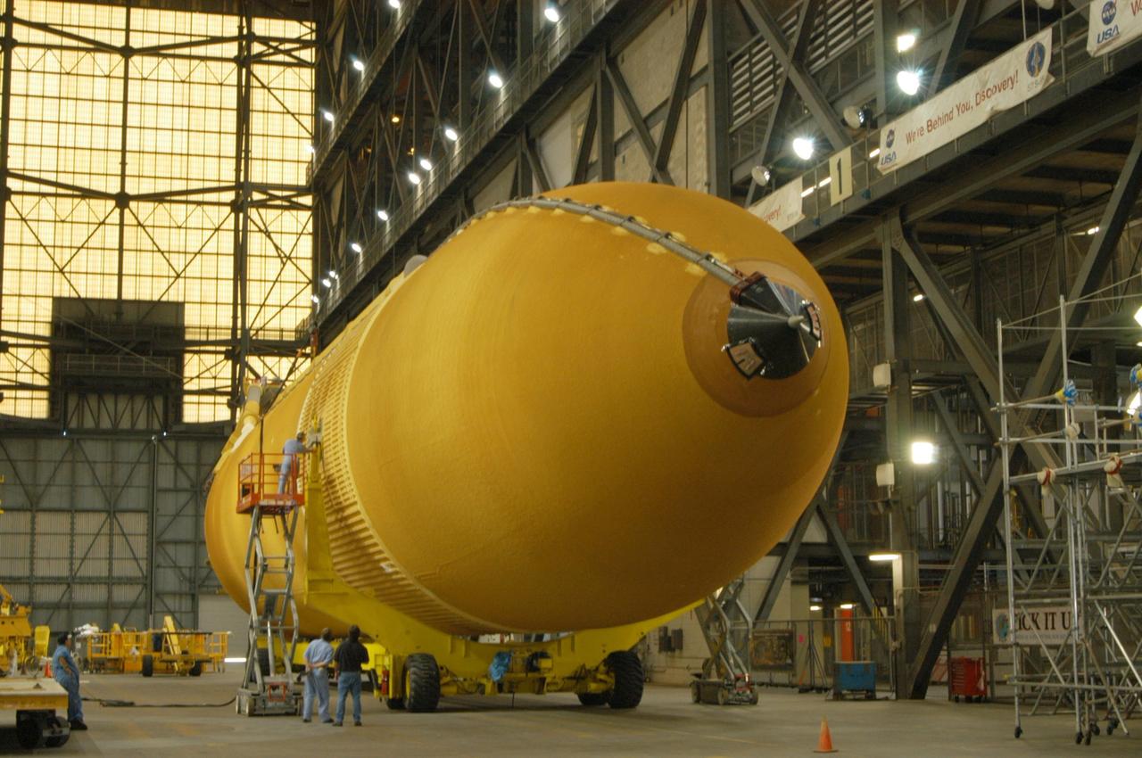 KENNEDY SPACE CENTER, FLA. - In the transfer aisle of NASA's Vehicle Assembly Building, the redesigned external fuel tank that will launch Space Shuttle Atlantis on the next shuttle mission, STS-115, is prepared to be raised to a vertical position. Once it is raised, the tank will be moved into a checkout cell for further work. The tank, designated ET-118, will fly with many major safety changes, including the removal of the protuberance air load ramps. Photo credit: NASA/George Shelton