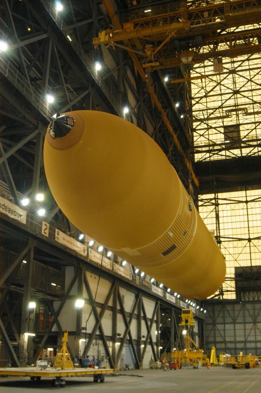 KENNEDY SPACE CENTER, FLA. - In NASA's Vehicle Assembly Building, the redesigned external fuel tank that will launch Space Shuttle Atlantis on the next shuttle mission, STS-115, is suspended above the transfer aisle where it will be raised to a vertical position. Once it is raised, the tank will be moved into a checkout cell for further work. The tank, designated ET-118, will fly with many major safety changes, including the removal of the protuberance air load ramps. Photo credit: NASA/George Shelton