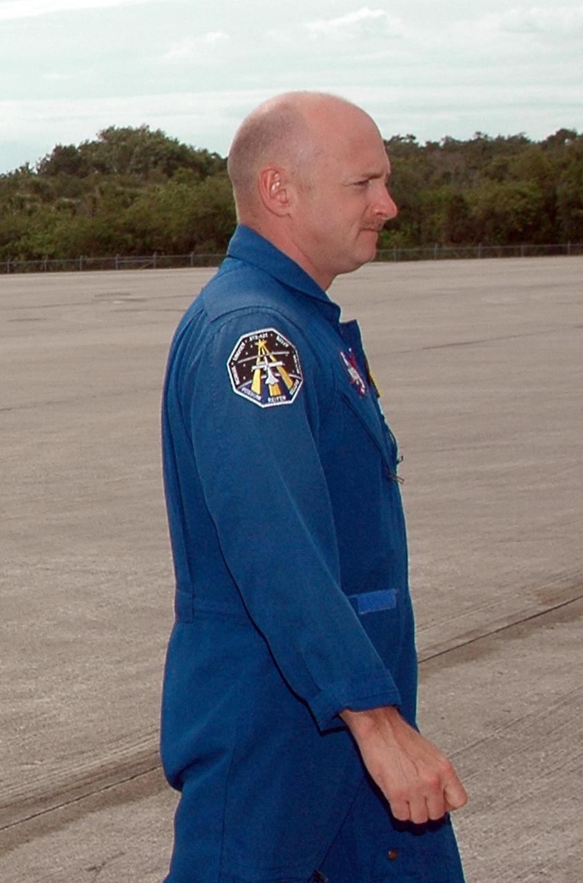 KENNEDY SPACE CENTER, FLA. - After landing at NASA's Kennedy Space Center aboard a Grumman G2 aircraft, the STS-121 crew gathers at a microphone for the media.  Seen here at center is Pilot Mark Kelly.  Other crew members are Mission Commander Steven Lindsey and Mission Specialists Michael Fossum, Lisa Nowak, Stephanie Wilson, Piers Sellers and Thomas Reiter, who represents the European Space Agency.  The crew is at the space center to take part in a Terminal Countdown Demonstration Test, or TCDT. Over several days, the crew will practice emergency egress from the pad and suit up in their orange flight suits for the simulated countdown to launch. Space Shuttle Discovery is designated to launch July 1 on mission STS-121.  It will carry supplies to the International Space Station.  Photo credit: NASA/Kim Shiflett