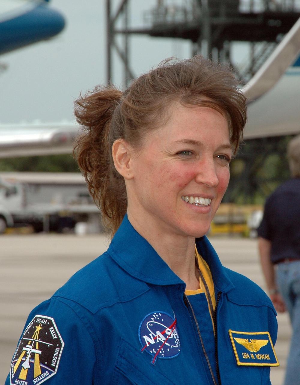KENNEDY SPACE CENTER, FLA. - After landing at NASA's Kennedy Space Center aboard a Grumman G2 aircraft, the STS-121 crew gathers at a microphone for the media.  Seen here at center is Mission Specialist Lisa Nowak; at left is Pilot Mark Kelly.  Other crew members are Mission Commander Steven Lindsey, Pilot Mark Kelly, and Mission Specialists Michael Fossum, Stephanie Wilson, Piers Sellers and Thomas Reiter, who represents the European Space Agency.  The crew is at the space center to take part in a Terminal Countdown Demonstration Test, or TCDT. Over several days, the crew will practice emergency egress from the pad and suit up in their orange flight suits for the simulated countdown to launch. Space Shuttle Discovery is designated to launch July 1 on mission STS-121.  It will carry supplies to the International Space Station.  Photo credit: NASA/Kim Shiflett