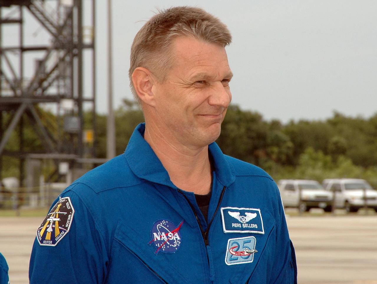 KENNEDY SPACE CENTER, FLA. - After landing at NASA's Kennedy Space Center aboard a Grumman G2 aircraft, the STS-121 crew gathers at a microphone for the media. Seen here at center is Mission Specialist Piers Sellers; at left is Mission Specialist Stephanie Wilson. Other crew members are Mission Commander Steven Lindsey, Mission Specialist Michael Fossum, Pilot Mark Kelly, and Mission Specialists Lisa Nowak and Thomas Reiter, who represents the European Space Agency. The crew is at the space center to take part in a Terminal Countdown Demonstration Test, or TCDT. Over several days, the crew will practice emergency egress from the pad and suit up in their orange flight suits for the simulated countdown to launch. Space Shuttle Discovery is designated to launch July 1 on mission STS-121. It will carry supplies to the International Space Station. Photo credit: NASA/Kim Shiflett