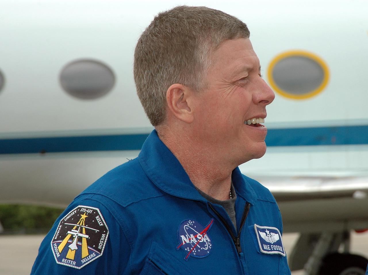 KENNEDY SPACE CENTER, FLA. - After landing at NASA's Kennedy Space Center aboard a Grumman G2 aircraft, the STS-121 crew gathers at a microphone for the media. Seen here is Mission Specialist Michael Fossum. Other crew members are Commander Steven Lindsey, Pilot Mark Kelly, and Mission Specialists Lisa Nowak, Stephanie Wilson, Piers Sellers and Thomas Reiter, who represents the European Space Agency. The crew is at the space center to take part in a Terminal Countdown Demonstration Test, or TCDT. Over several days, the crew will practice emergency egress from the pad and suit up in their orange flight suits for the simulated countdown to launch. Space Shuttle Discovery is designated to launch July 1 on mission STS-121. It will carry supplies to the International Space Station. Photo credit: NASA/Kim Shiflett