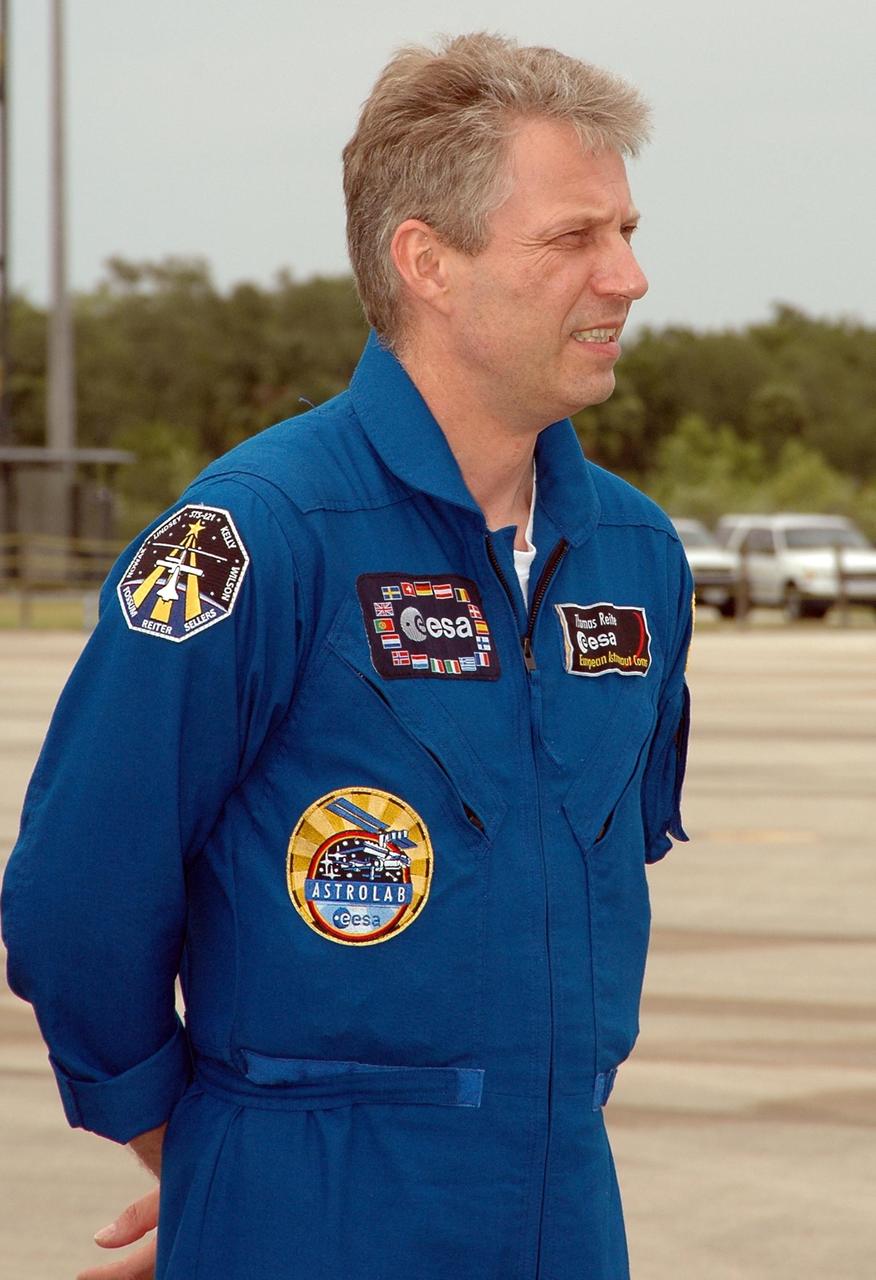 KENNEDY SPACE CENTER, FLA. - After landing at NASA's Kennedy Space Center aboard a Grumman G2 aircraft, the STS-121 crew gathers at a microphone for the media.  Seen here is Mission Specialist Thomas Reiter from Germany, who represents the European Space Agency.  Other crew members are Commander Steven Lindsey, Pilot Mark Kelly, and Mission Specialists Michael Fossum, Lisa Nowak, Stephanie Wilson and Piers Sellers. The crew is at the space center to take part in a Terminal Countdown Demonstration Test, or TCDT. Over several days, the crew will practice emergency egress from the pad and suit up in their orange flight suits for the simulated countdown to launch. Space Shuttle Discovery is designated to launch July 1 on mission STS-121.  It will carry supplies to the International Space Station.  Photo credit: NASA/Kim Shiflett