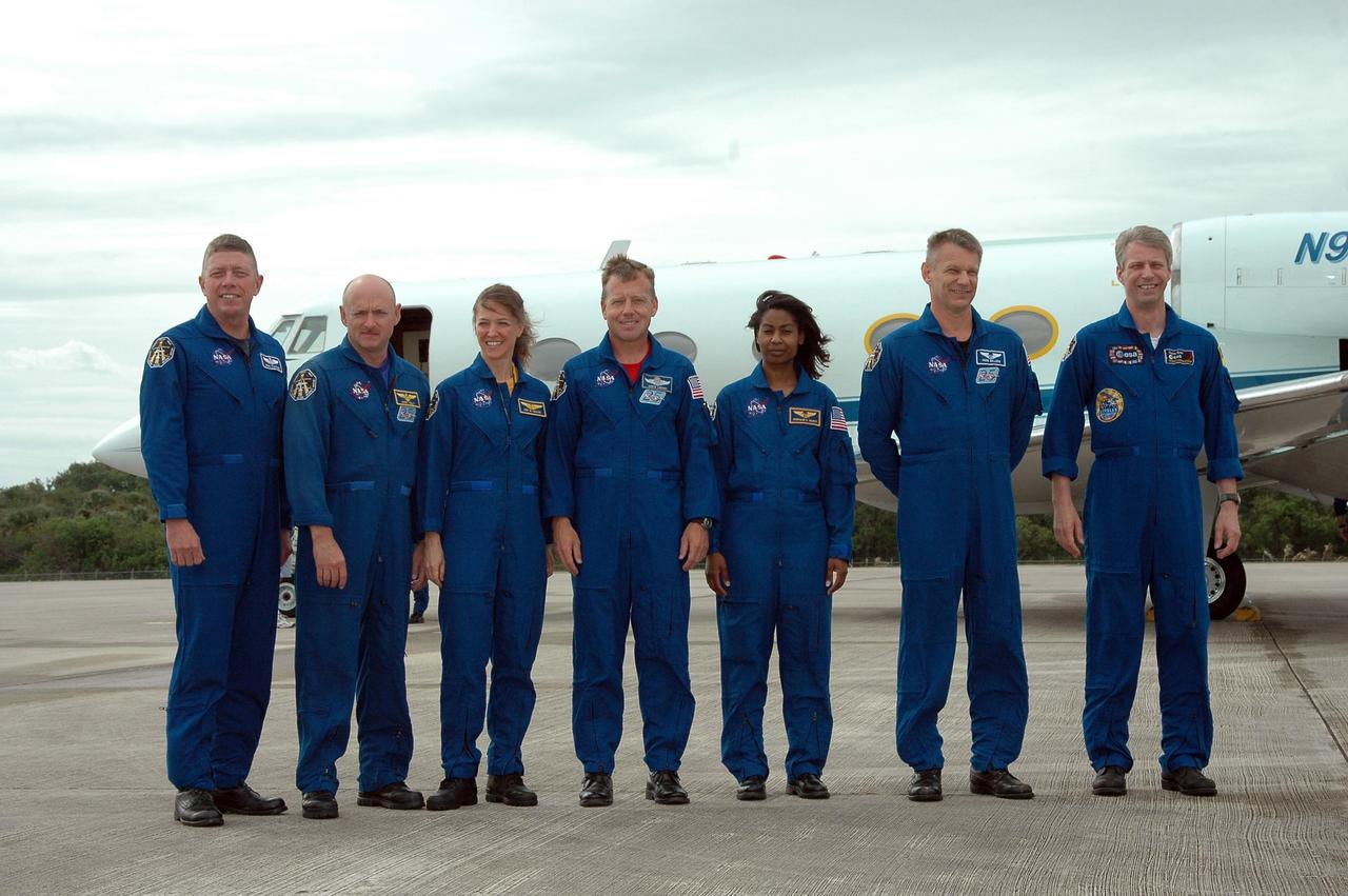 KENNEDY SPACE CENTER, FLA. - After their arrival at NASA's Kennedy Space Center, the STS-121 crew poses for a photo.  From left are Mission Specialist Michael Fossum, Pilot Mark Kelly, Mission Specialist Lisa Nowak, Commander Steven Lindsey and Mission Specialists Stephanie Wilson, Piers Sellers and Thomas Reiter from Germany, who represents the European Space Agency.  The crew is at the space center to take part in a Terminal Countdown Demonstration Test, or TCDT. Over several days, the crew will practice emergency egress from the pad and suit up in their orange flight suits for the simulated countdown to launch. Space Shuttle Discovery is designated to launch July 1 on mission STS-121.  It will carry supplies to the International Space Station.  Photo credit: NASA/Kim Shiflett