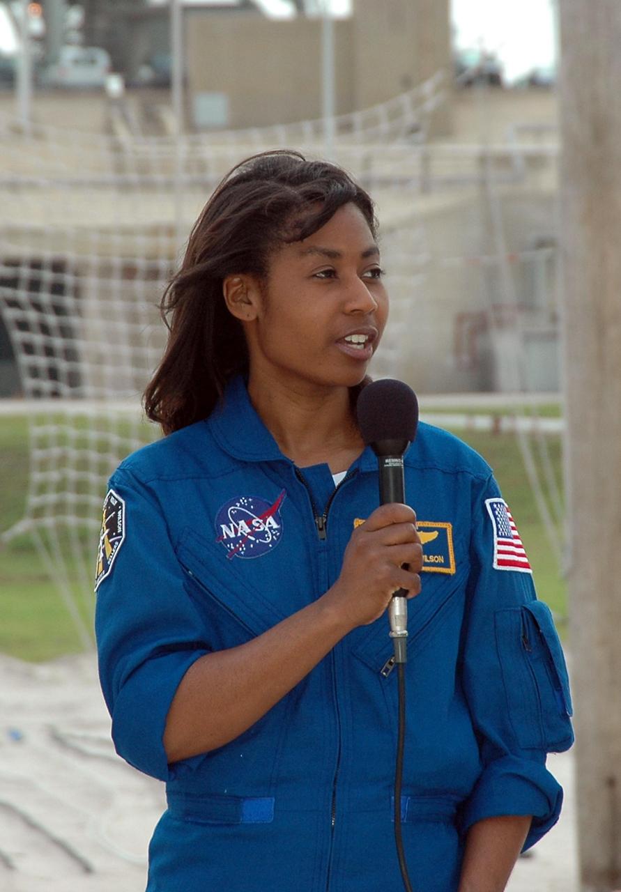 KENNEDY SPACE CENTER, FLA. - During a pause in their prelaunch activities at the pad, the STS-121 crew talk to the media. They are standing in the landing area of the slidewire baskets. With the microphone is Mission Specialist Stephanie Wilson. The crew is at Kennedy for Terminal Countdown Demonstration Test activities. Over several days, the crew will practice emergency egress from the pad and suit up in their orange flight suits for the simulated countdown to launch. Space Shuttle Discovery is designated to launch July 1 on mission STS-121. It will carry supplies to the International Space Station. Photo credit: NASA/Kim Shiflett