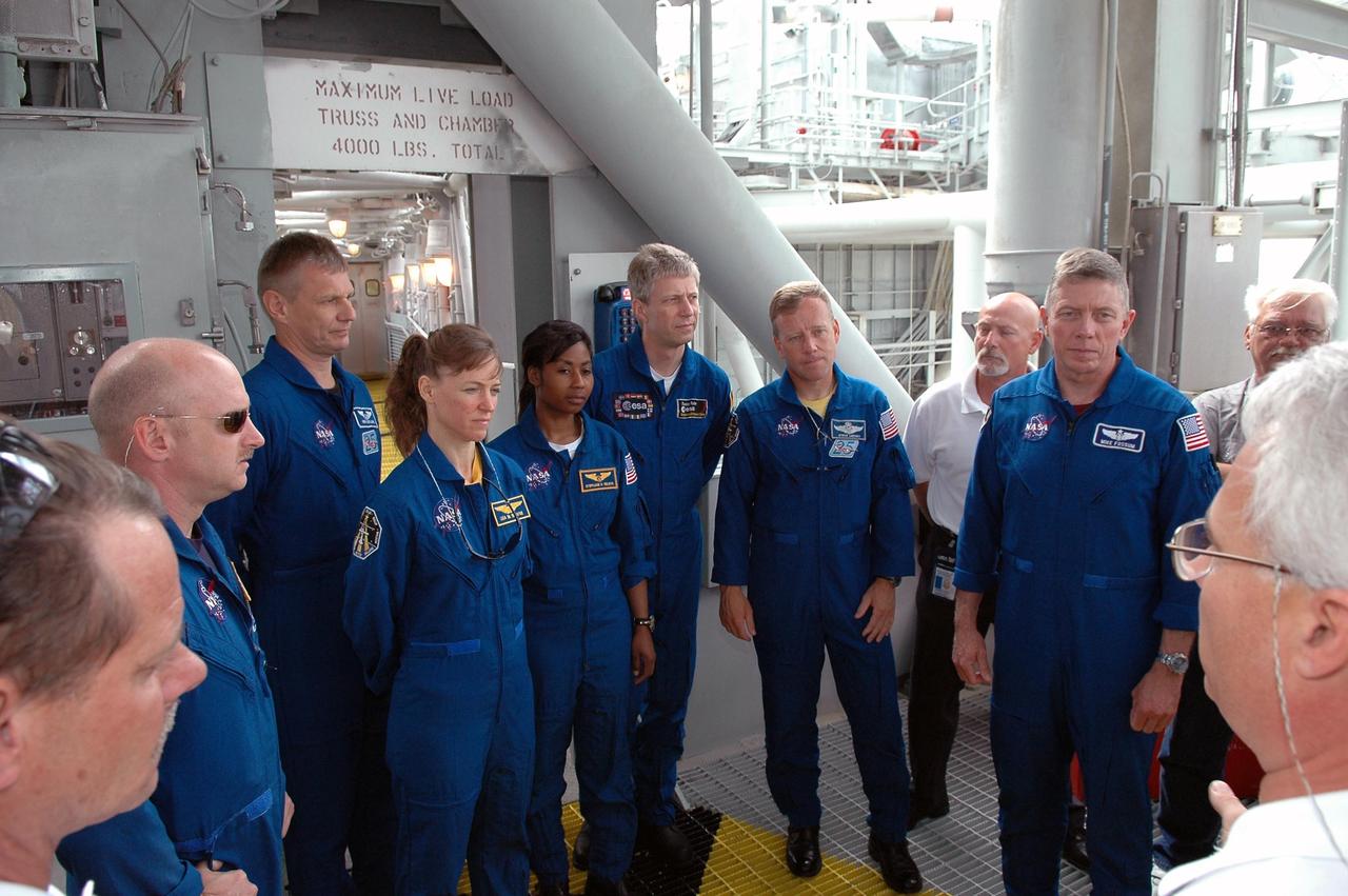 KENNEDY SPACE CENTER, FLA. -   The STS-121 crew listens to instructions on emergency egress from the pad.  The crew members are (from left) Pilot Mark Kelly, Mission Specialists Piers Sellers, Lisa Nowak, Stephanie Wilson and Thomas Reiter, Commander Steven Lindsey, and Mission Specialist Michael Fossum.  Reiter is from Germany and represents the European Space Agency.  The crew is at Kennedy for Terminal Countdown Demonstration Test activities, including emergency egress training from the pad.  They will also suit up in their orange flight suits for a simulated countdown to launch. Discovery is designated to launch July 1 on mission STS-121.  It will carry supplies to the International Space Station.  Photo credit: NASA/Kim Shiflett