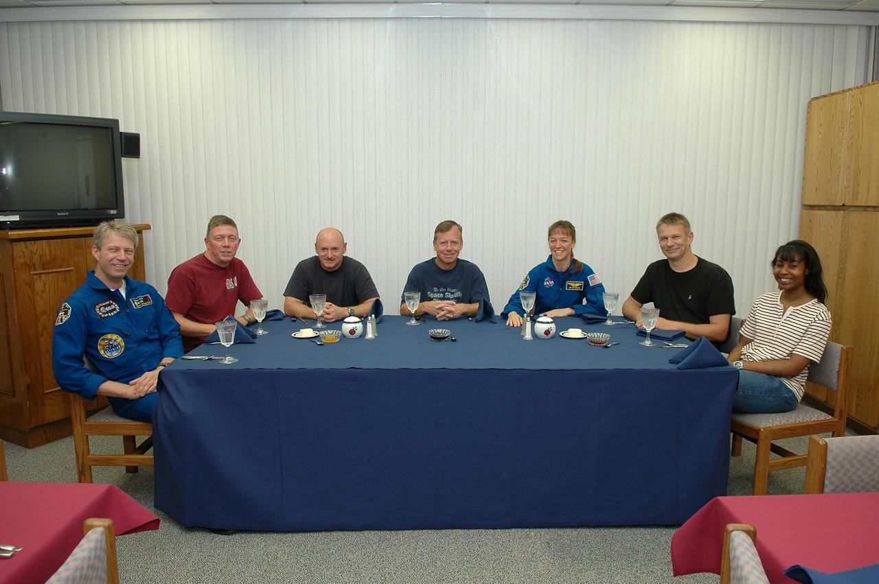 KENNEDY SPACE CENTER, FLA. -  The STS-121 crew have breakfast in the Operations and Checkout Building at NASA's Kennedy Space Center before suiting up for the simulated countdown at the launch pad.  Seated left to right are Mission Specialists Thomas Reiter of Germany and Michael Fossum, Pilot Mark Kelly, Commander Steven Lindsey, and Mission Specialists Lisa Nowak, Piers Sellers and Stephanie Wilson.  Reiter represents the European Space Agency.  The crew is taking part in Terminal Countdown Demonstration Test activities, including the dress rehearsal for launch. Mission STS-121 is scheduled to be launched July 1.  Photo credit: NASA/Kim Shiflett