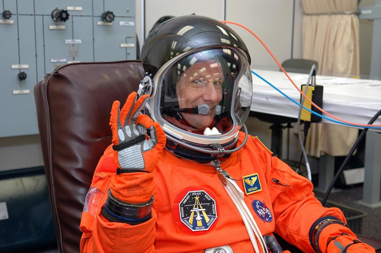KENNEDY SPACE CENTER, FLA. - STS-121 Mission Specialist Piers Sellers signals okay after donning his launch and entry suit in preparation for the simulated countdown he and other crew members will undertake. The crew is taking part in Terminal Countdown Demonstration Test activities, including the dress rehearsal for launch. Mission STS-121 is scheduled to be launched July 1. Photo credit: NASA/Kim Shiflett