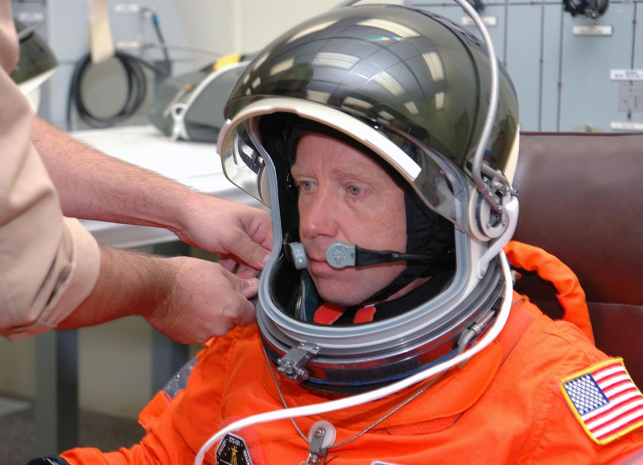 KENNEDY SPACE CENTER, FLA. - STS-121 Commander Steven Lindsey has his helmet secured to his launch and entry suit in preparation for the simulated countdown he and other crew members will undertake. The crew is taking part in Terminal Countdown Demonstration Test activities, including the dress rehearsal for launch. Mission STS-121 is scheduled to be launched July 1. Photo credit: NASA/Kim Shiflett