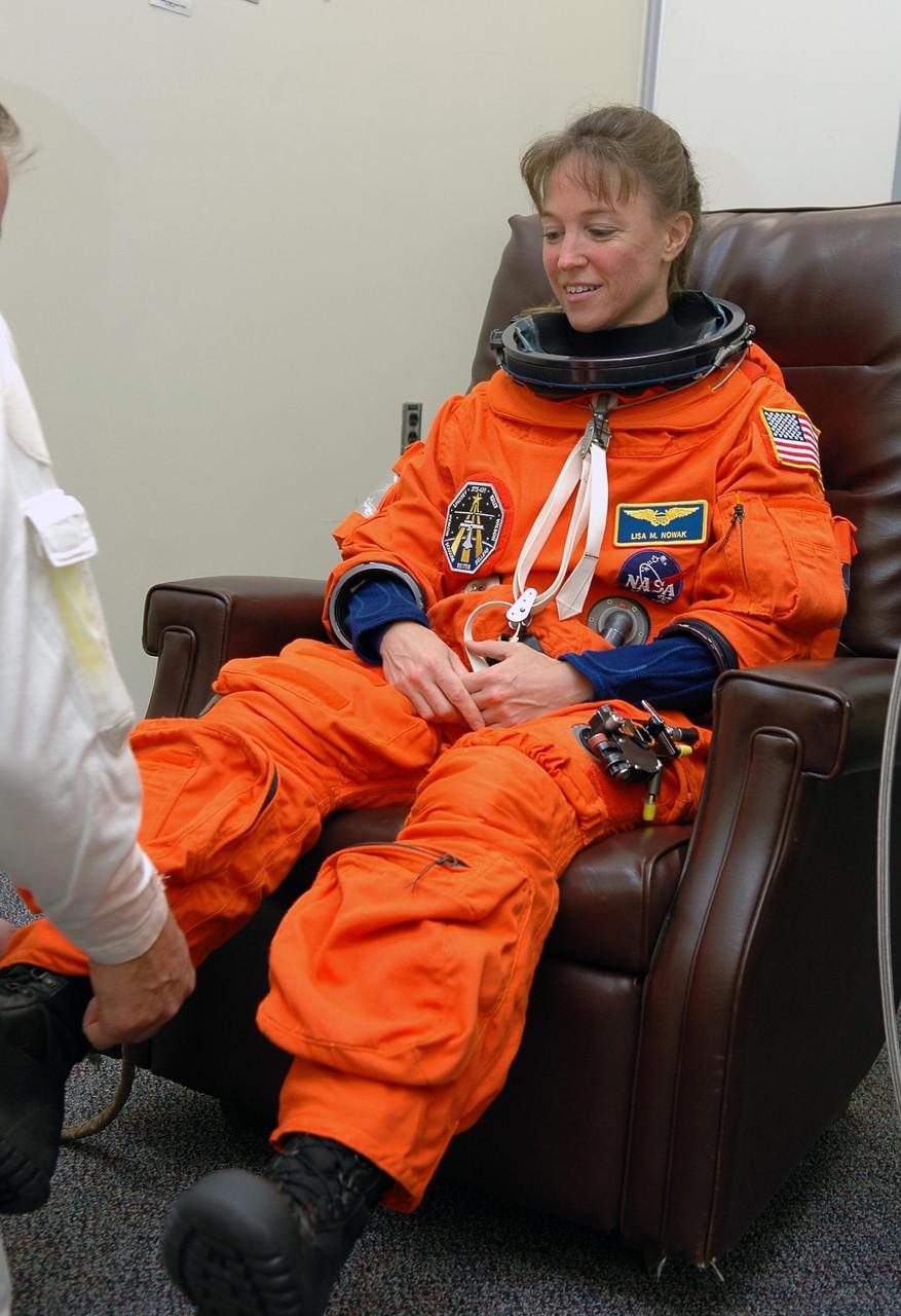 KENNEDY SPACE CENTER, FLA. - STS-121 Mission Specialist Lisa Nowak is helped with her boot after donning her launch and entry suit in preparation for the simulated countdown she and other crew members will undertake. The crew is taking part in Terminal Countdown Demonstration Test activities, including the dress rehearsal for launch. Mission STS-121 is scheduled to be launched July 1. Photo credit: NASA/Kim Shiflett