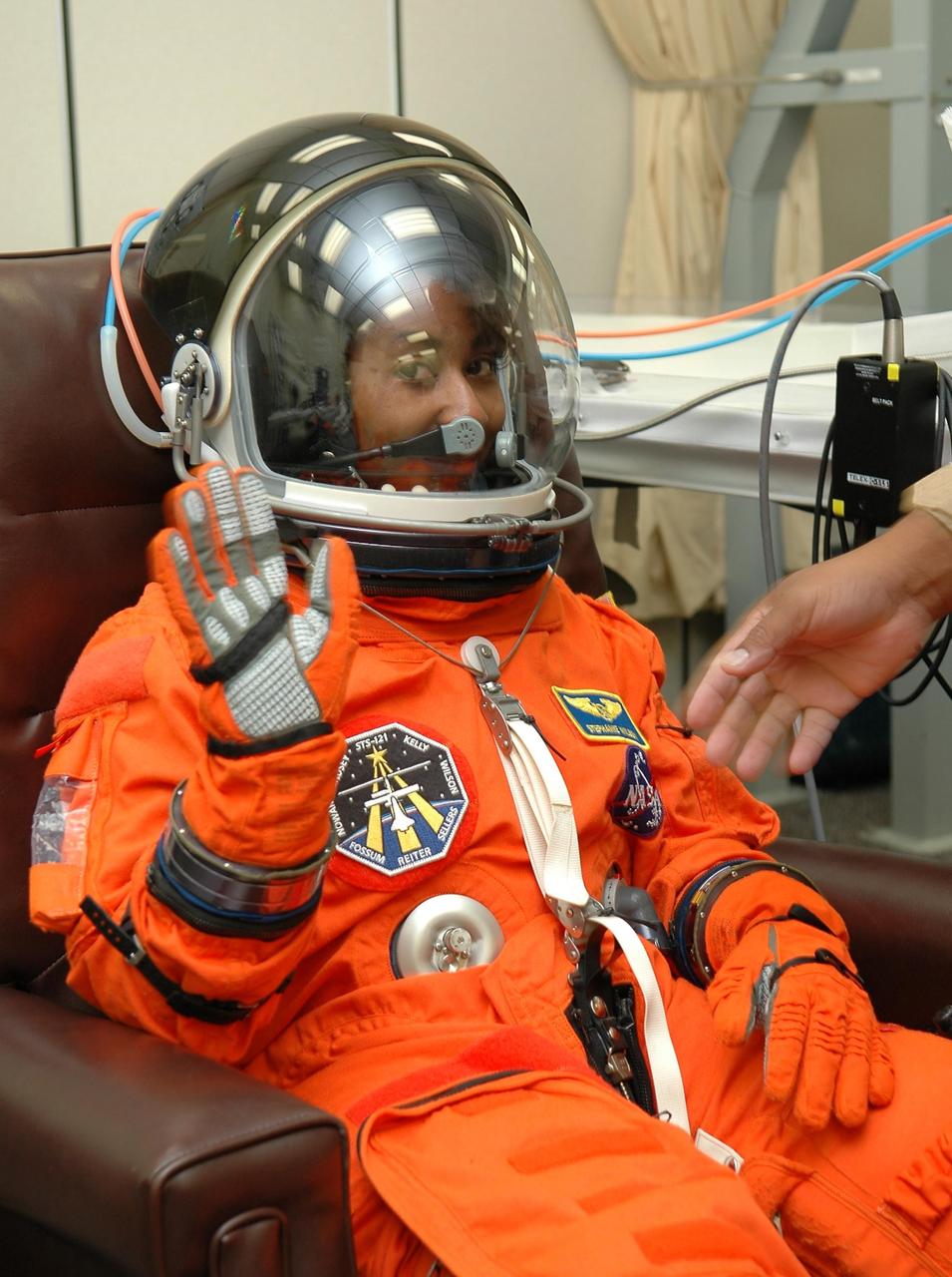 KENNEDY SPACE CENTER, FLA. - STS-121 Mission Specialist Stephanie Wilson signals all is well after donning her launch and entry suit in preparation for the simulated countdown she and other crew members will undertake. The crew is taking part in Terminal Countdown Demonstration Test activities, including the dress rehearsal for launch. Mission STS-121 is scheduled to be launched July 1. Photo credit: NASA/Kim Shiflett