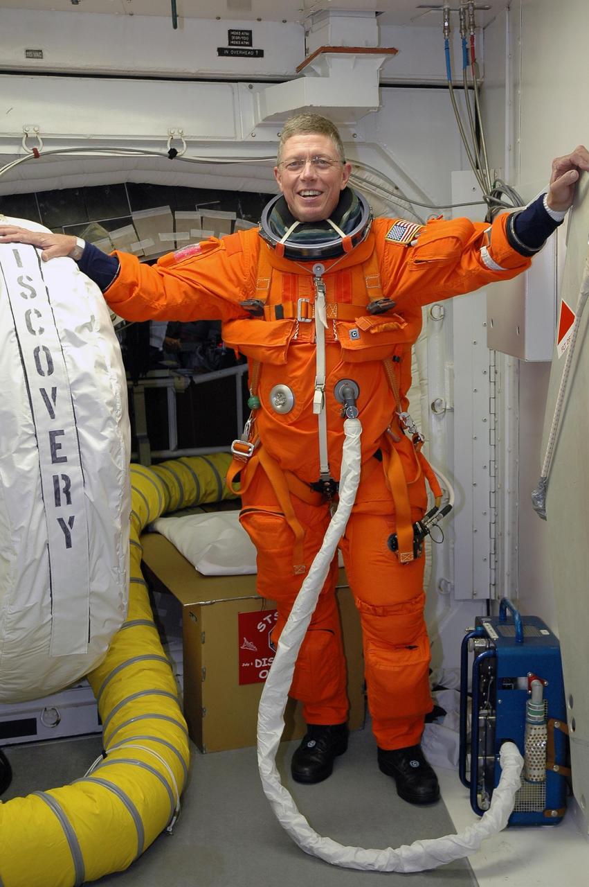 KENNEDY SPACE CENTER, FLA. -  In the White Room on Launch Pad 39B, STS-121 Mission Specialist Michael Fossum enjoys a portable cooling unit keeping him cool while waiting to enter Space Shuttle Discovery. The crew is taking part in a full dress rehearsal for launch, including countdown and culminating in main engine cutoff. The rehearsal is the final part of Terminal Countdown Demonstration Test (TCDT) activities that the crew has been involved in for two days. TCDT provides the crew of each mission an opportunity to participate in various simulated countdown activities, including equipment familiarization and emergency egress training. Mission STS-121 is scheduled to be launched July 1. Photo credit: NASA/Amanda Diller