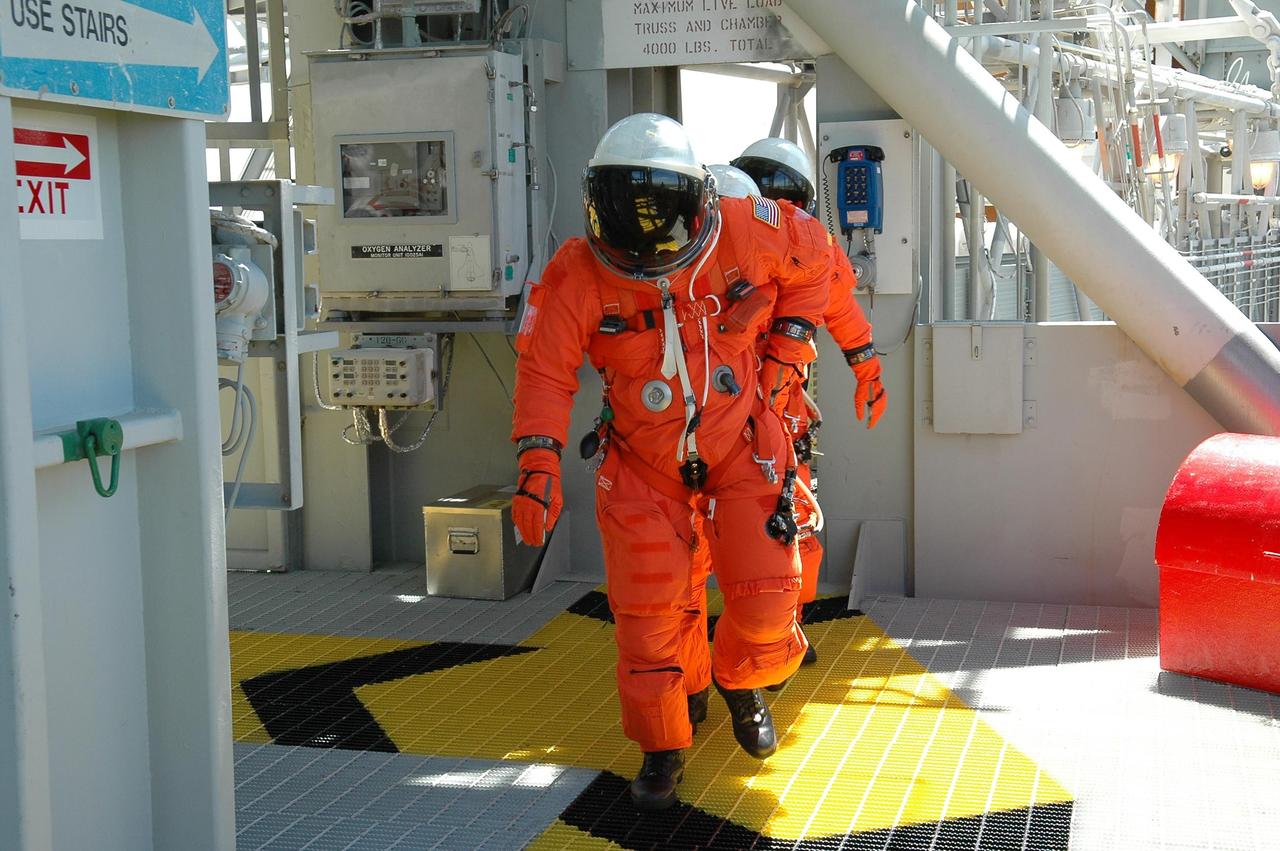 KENNEDY SPACE CENTER, FLA. - STS-121 crew members follow the route to the slidewire baskets on Launch Pad 39B. They are taking part in emergency egress practice, part of the Terminal Countdown Demonstration Test (TCDT) activities that include a simulated countdown culminating in main engine cutoff. Mission STS-121 is scheduled to be launched July 1. Photo credit: NASA/Kim Shiflett