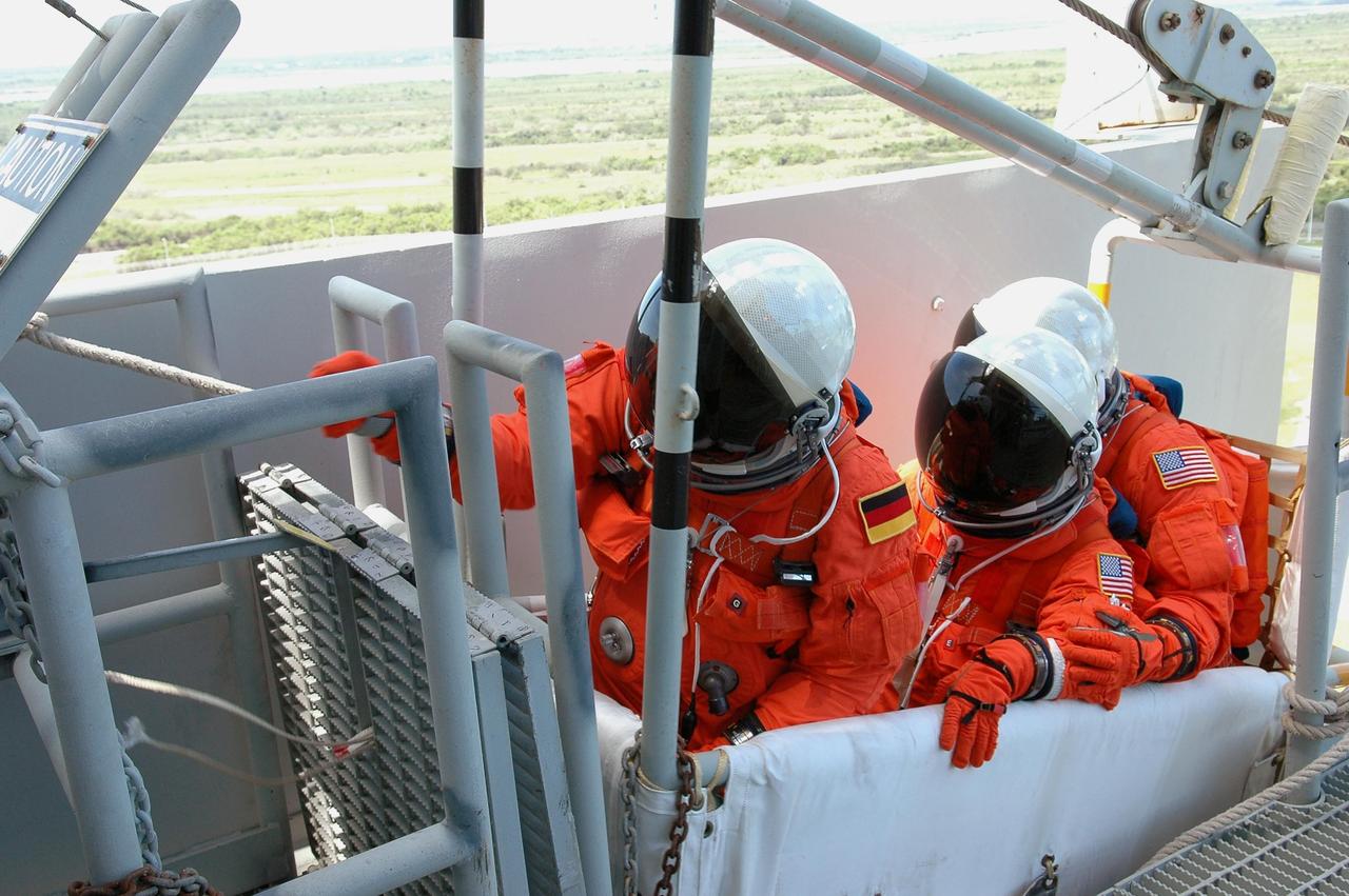 KENNEDY SPACE CENTER, FLA. - STS-121 crew members wait for the release of the slidewire basket on Launch Pad 39B. They are taking part in emergency egress practice, part of the Terminal Countdown Demonstration Test (TCDT) activities that include a simulated countdown culminating in main engine cutoff. Mission STS-121 is scheduled to be launched July 1. Photo credit: NASA/Kim Shiflett