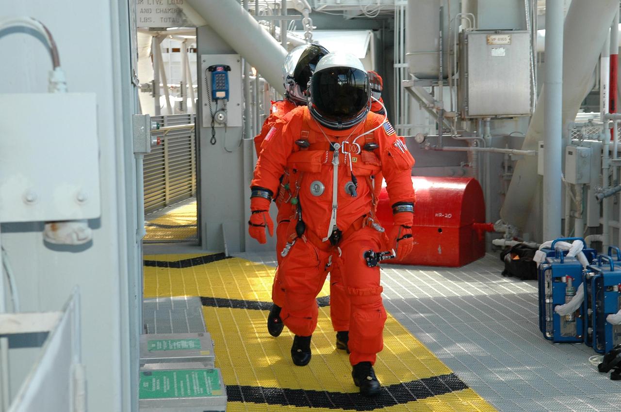 KENNEDY SPACE CENTER, FLA. - STS-121 crew members follow the route to the slidewire baskets on Launch Pad 39B. They are taking part in emergency egress practice, part of the Terminal Countdown Demonstration Test (TCDT) activities that include a simulated countdown culminating in main engine cutoff. Mission STS-121 is scheduled to be launched July 1. Photo credit: NASA/Kim Shiflett