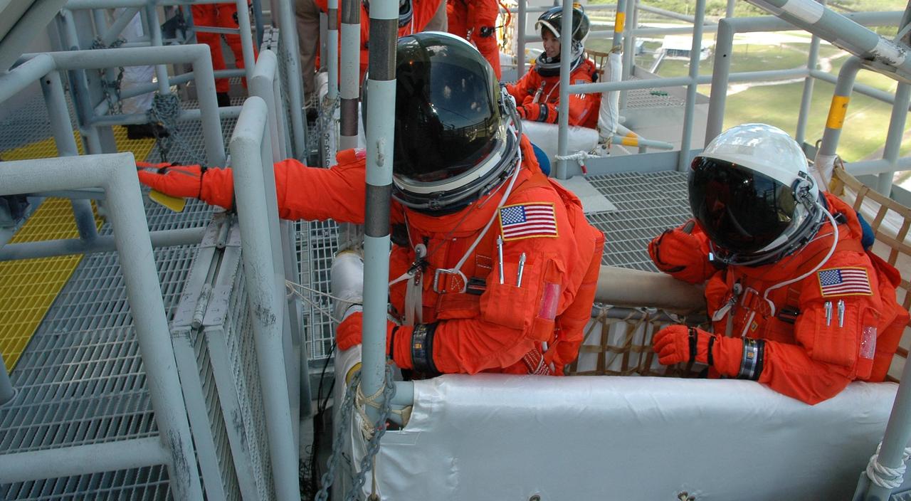 KENNEDY SPACE CENTER, FLA. - STS-121 crew members wait to climb into the slidewire basket on Launch Pad 39B. They are taking part in emergency egress practice, part of the Terminal Countdown Demonstration Test (TCDT) activities that include a simulated countdown culminating in main engine cutoff. Mission STS-121 is scheduled to be launched July 1. Photo credit: NASA/Kim Shiflett