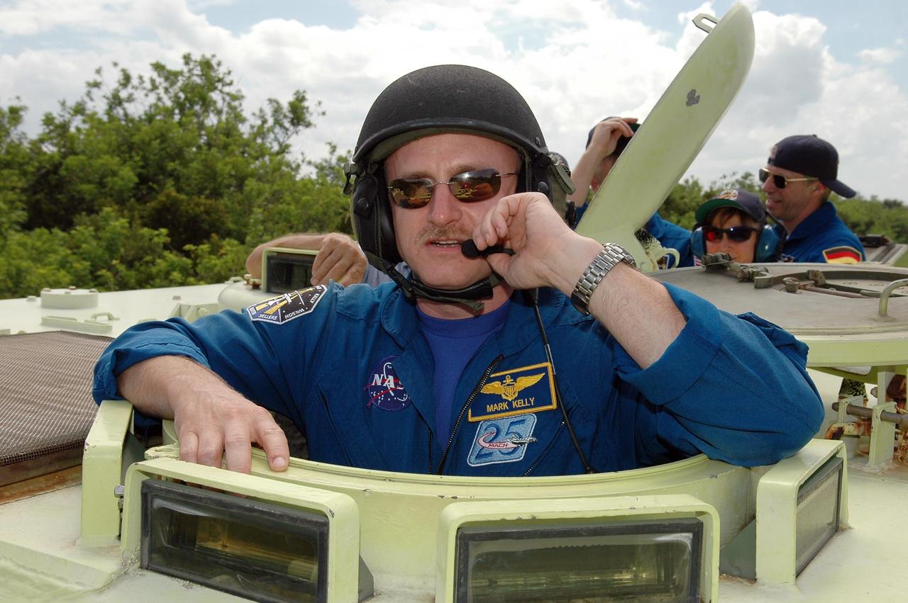 KENNEDY SPACE CENTER, FLA. -   STS-121 Pilot Mark Kelly takes his turn in an M-113, which is an armored personnel carrier. Behind him can be seen Mission Specialists Lisa Nowak and Thomas Reiter from Germany, who represents the European Space Agency. The STS-121 crew is taking turns driving the M-113 as part of Terminal Countdown Demonstration Test activities, which include emergency egress training from the pad and a simulated countdown.  Mission STS-121 is designated for launch on July 1.   Photo credit: NASA/Kim Shiflett