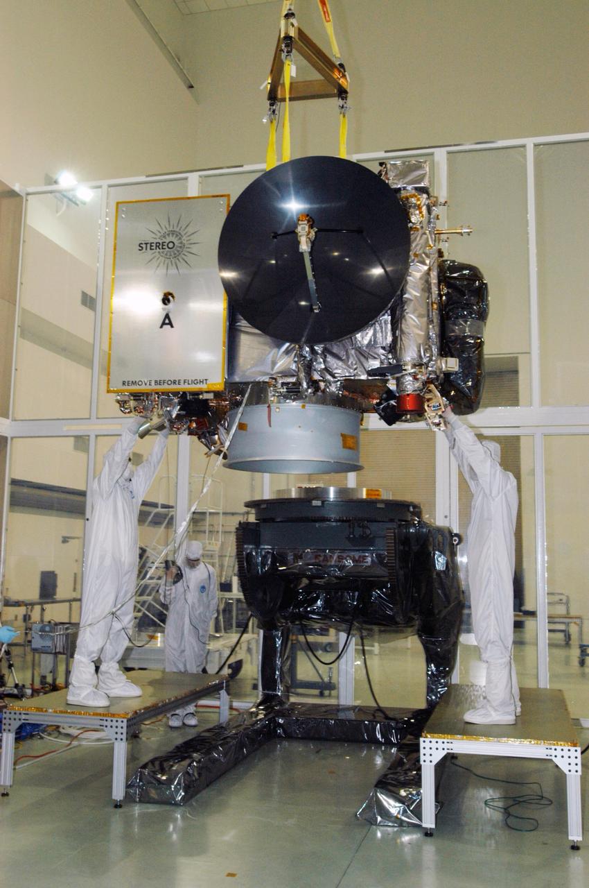 KENNEDY SPACE CENTER, FLA. - At Astrotech Space Operations in Titusville, Fla., technicians help guide the STEREO spacecraft "A" toward a tilt table. On the table, the observatory will be tilted down so that technicians can perform the final comprehensive performance test of the instruments, verifying the instrument is fully functional before flight. After a rotation, this configuration also allows deployment tests to be done on the solar arrays. STEREO stands for Solar Terrestrial Relations Observatory. The STEREO mission is the first to take measurements of the sun and solar wind in 3-dimension. This new view will improve our understanding of space weather and its impact on the Earth. STEREO is expected to lift off aboard a Boeing Delta II rocket on July 22. Photo credit: NASA/George Shelton