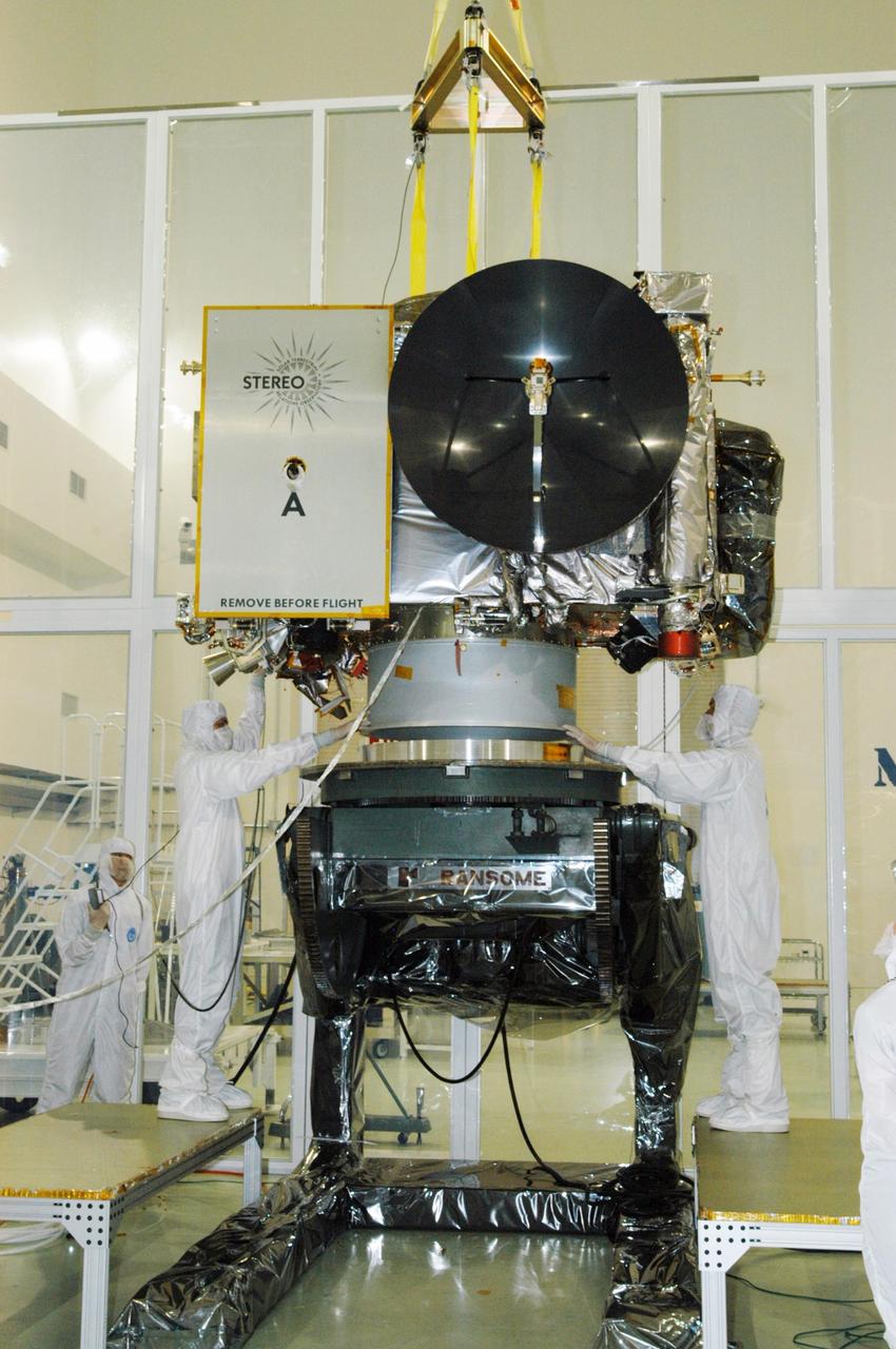 KENNEDY SPACE CENTER, FLA. - At Astrotech Space Operations in Titusville, Fla., technicians help guide the STEREO spacecraft "A" as it is lowered onto a tilt table. On the table, the observatory will be tilted down so that technicians can perform the final comprehensive performance test of the instruments, verifying the instrument is fully functional before flight. After a rotation, this configuration also allows deployment tests to be done on the solar arrays. STEREO stands for Solar Terrestrial Relations Observatory. The STEREO mission is the first to take measurements of the sun and solar wind in 3-dimension. This new view will improve our understanding of space weather and its impact on the Earth. STEREO is expected to lift off aboard a Boeing Delta II rocket on July 22. Photo credit: NASA/George Shelton